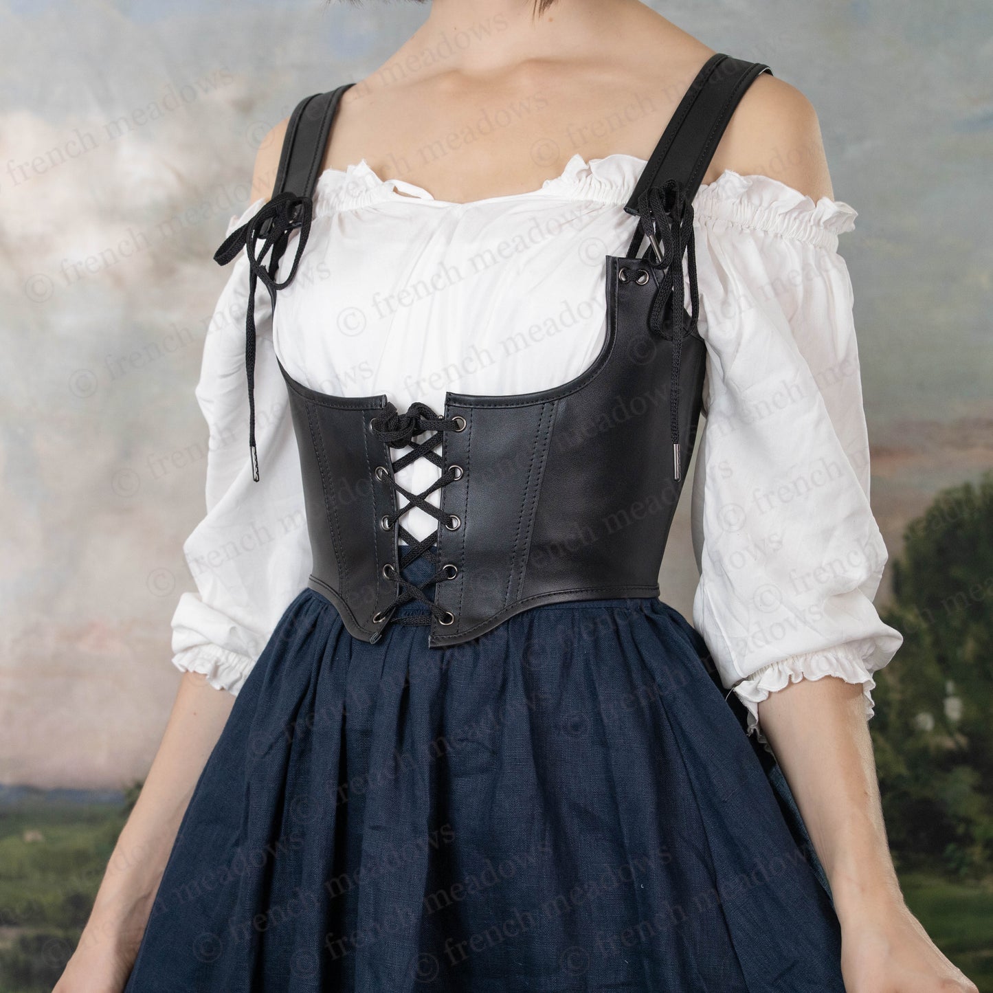 Black leather underbust corset belt with lace-up front paired with white peasant blouse and navy skirt in Renaissance style