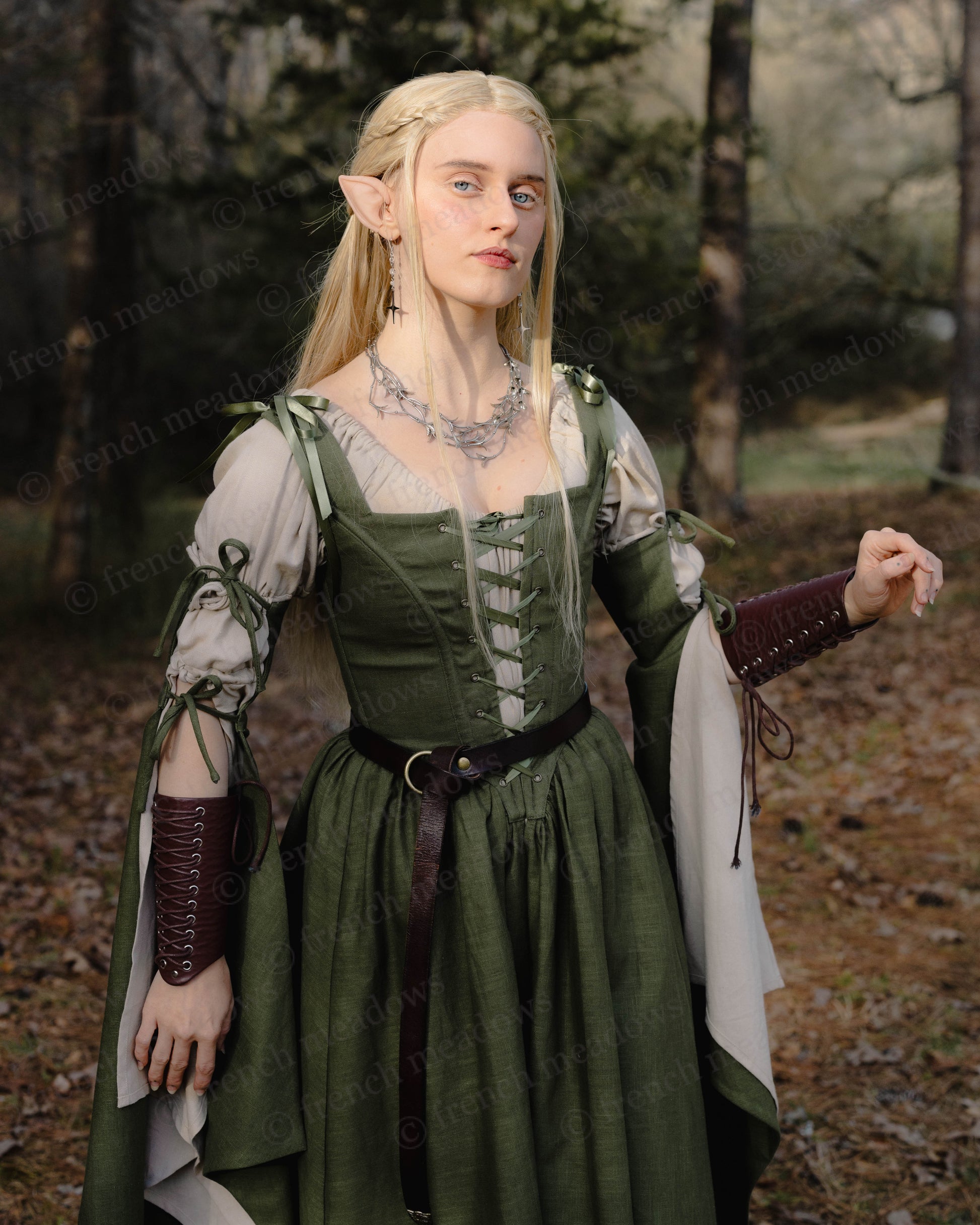 Ivy Green Corset Dress with medieval linen design featuring bell sleeves and lace-up bodice in woodland forest setting