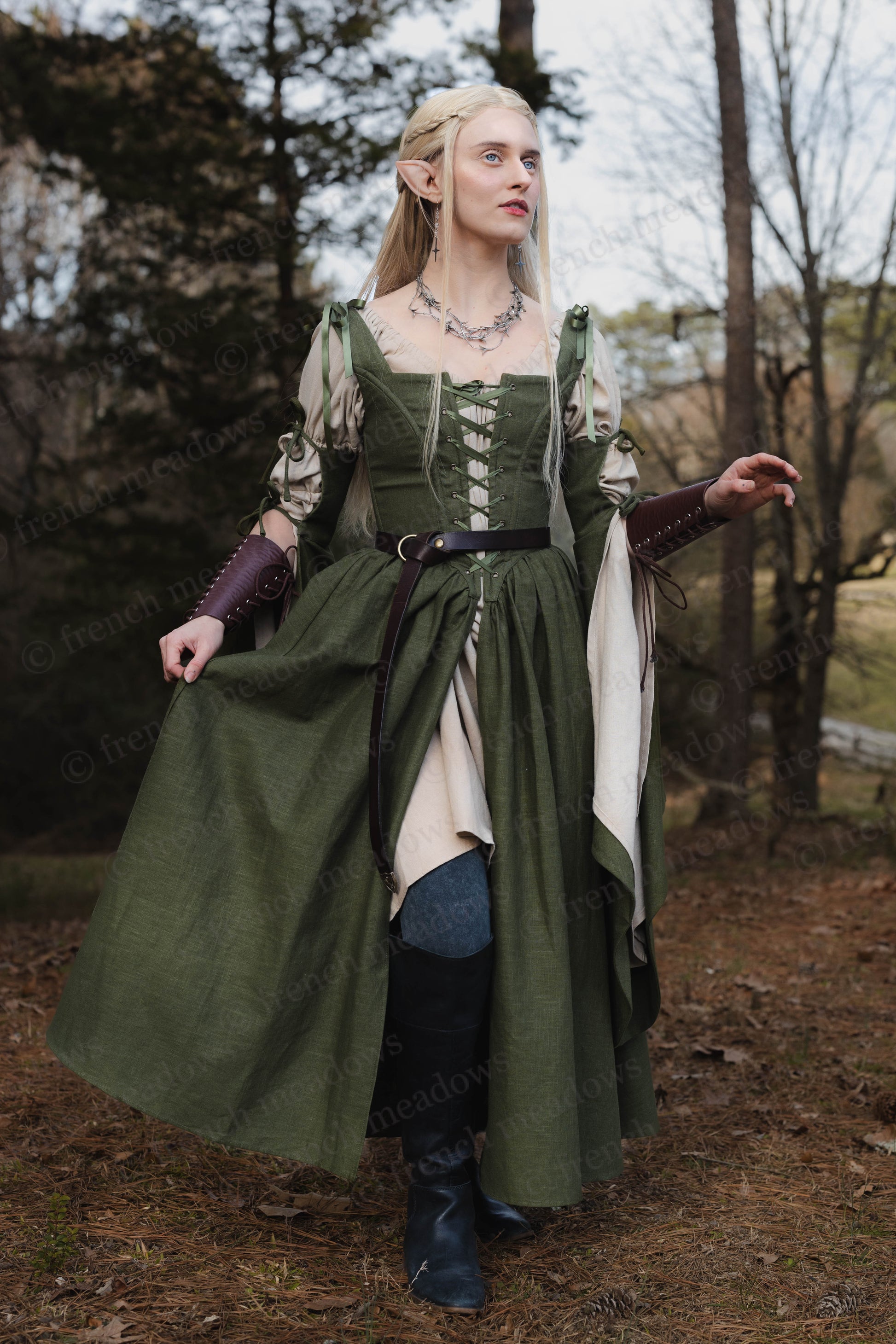 Ivy Green Corset Dress with flowing bell sleeves and laced bodice shown in enchanted forest setting, medieval fantasy style