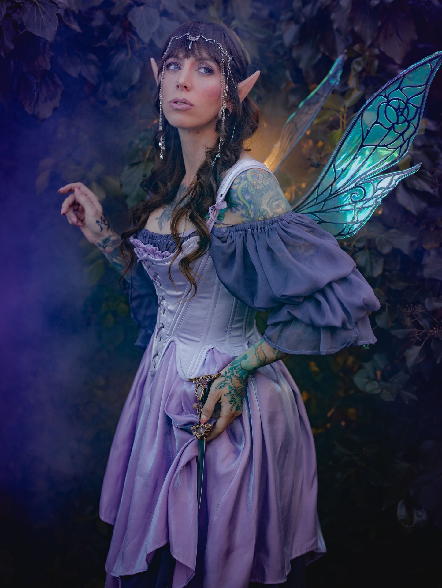 Lilac Satin 18th Century Stays worn by a fae figure with pointed ears and decorative wings in a forest setting.