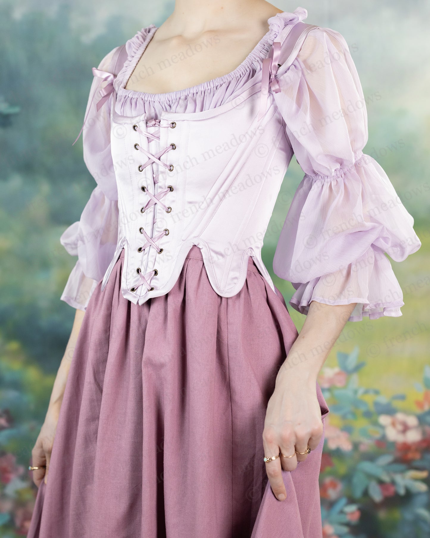 Lilac Satin 18th Century Stays with lace-up front, scoop neckline, and billowing sleeves worn over a dusty rose skirt