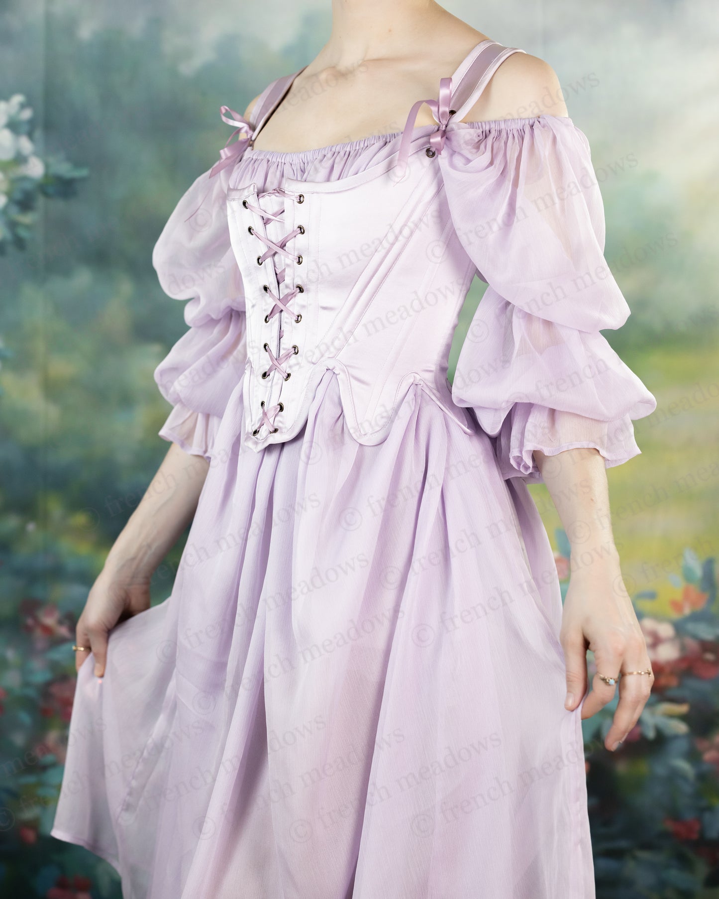 Lilac Satin 18th Century Stays with off-shoulder puff sleeves and front lacing, shown in ethereal garden setting