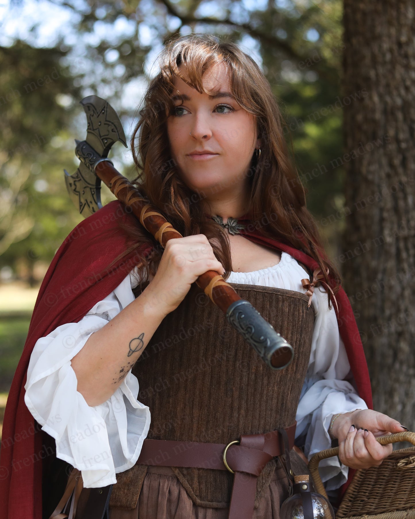 Brown Tabbed Tudor Stays shown in medieval costume with red cloak and decorative battle axe in outdoor woodland setting
