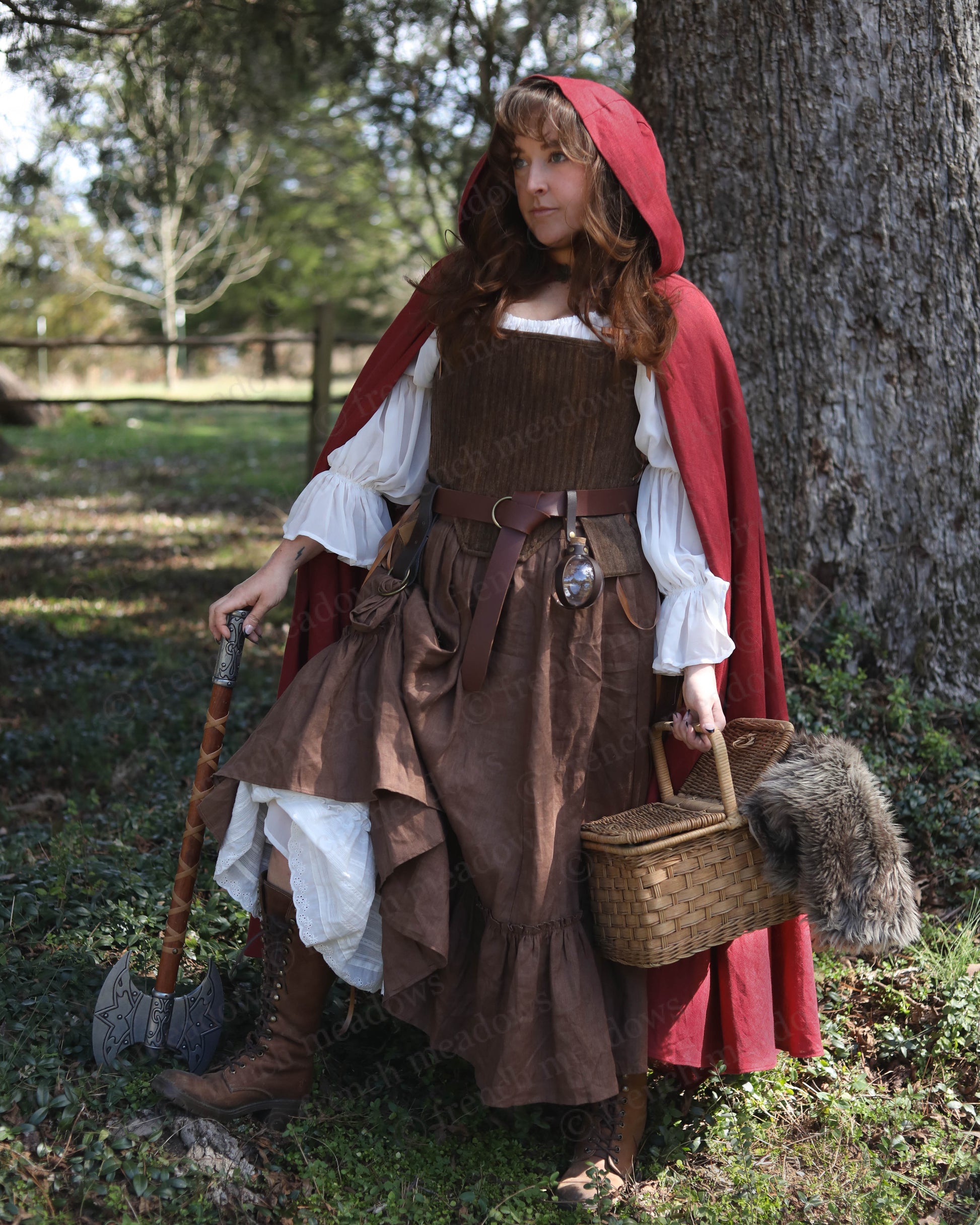 Brown Tabbed Tudor Stays shown in medieval costume with red cloak, white chemise and brown dress in woodland setting