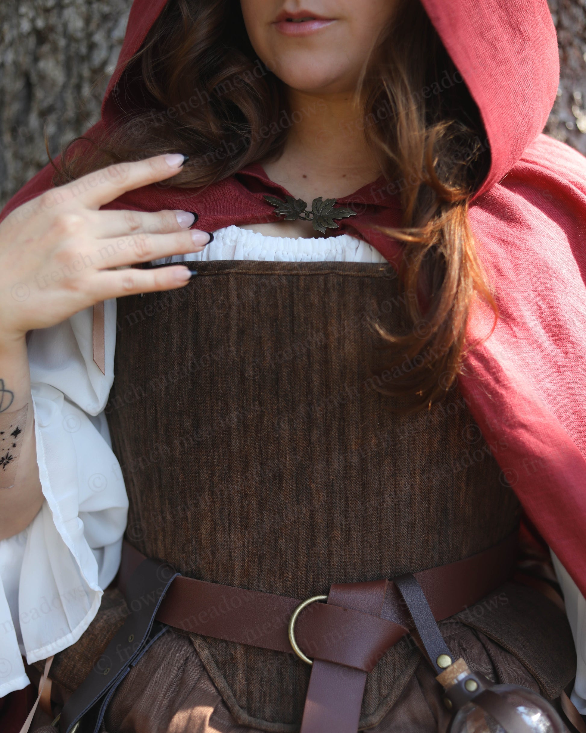 Brown Tabbed Tudor Stays shown with red cloak and white chemise, featuring medieval-style corset bodice and leather belt