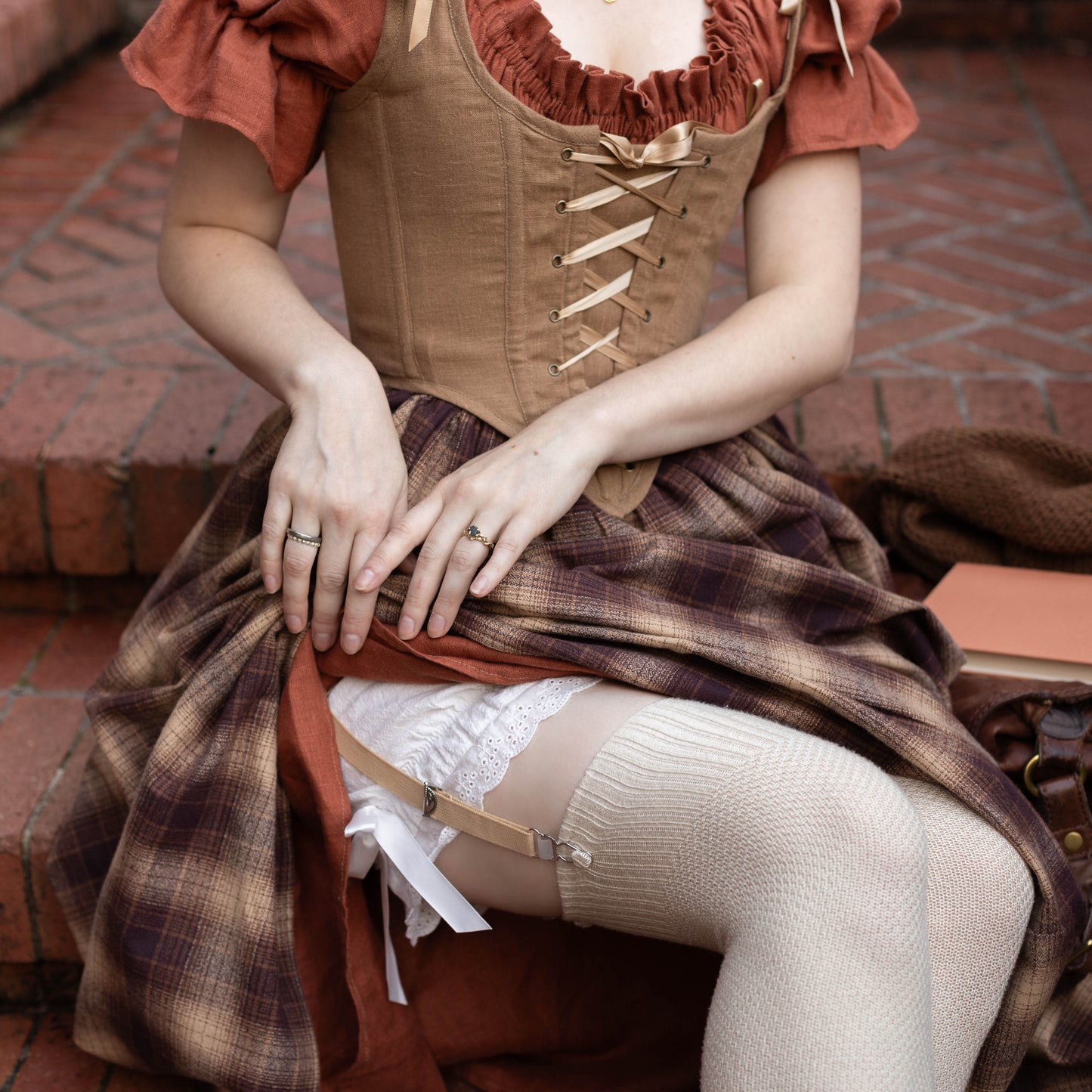 Victorian Bloomers shown with white lace trim and bow details under plaid dress with corset bodice