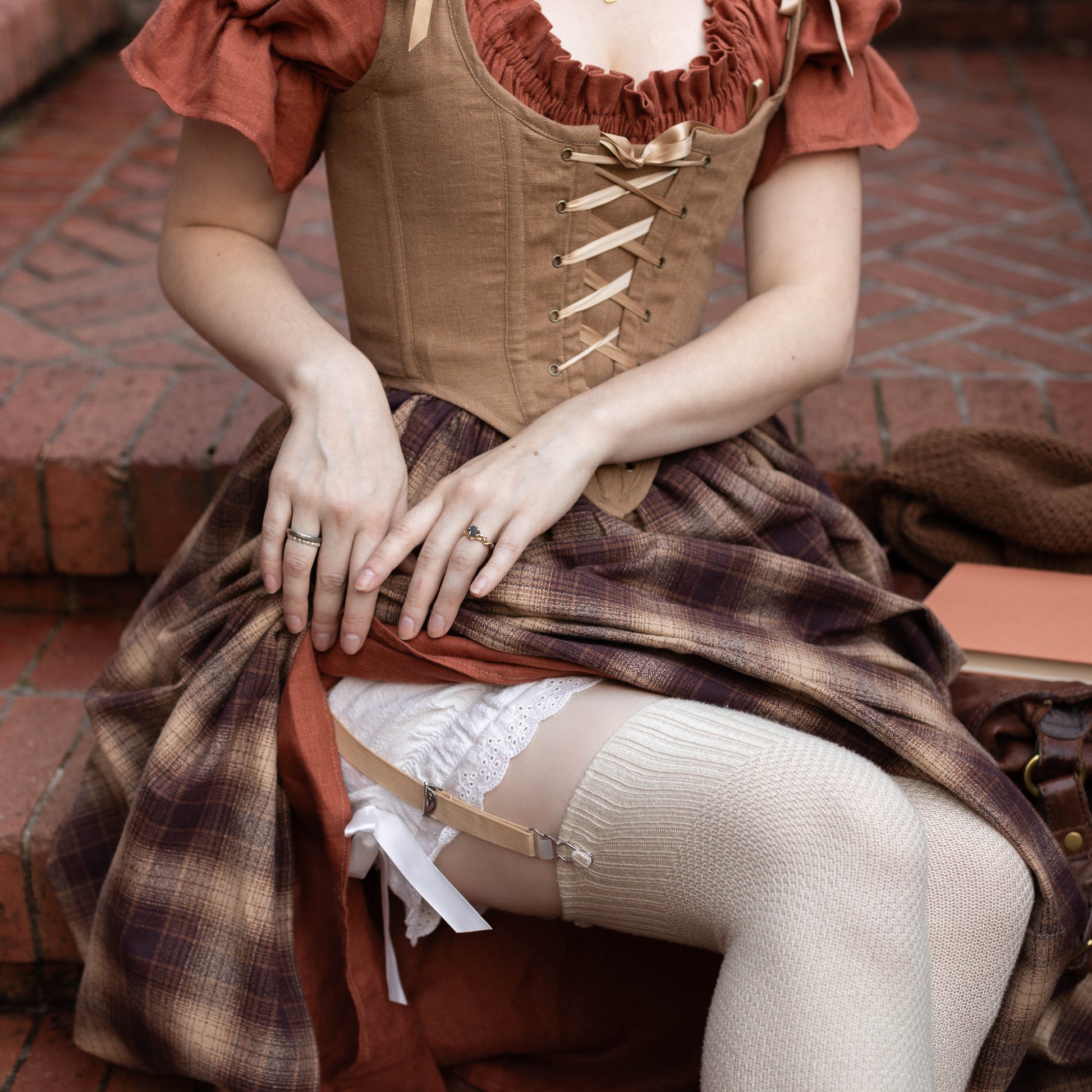 Victorian Bloomers shown with white lace trim and bow details under plaid dress with corset bodice
