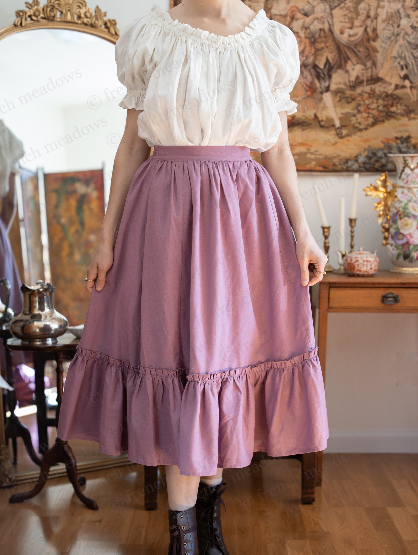 Mauve Linen Ruffle Skirt styled with white peasant blouse in vintage cottage room setting, showcasing flowy midi length and ruffled hem