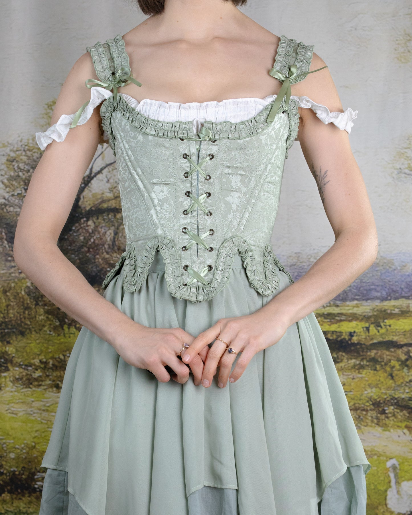 Mint Green Floral 18th Century Stays with ruffled neckline, floral satin fabric, front and back lacing, and waist tabs.