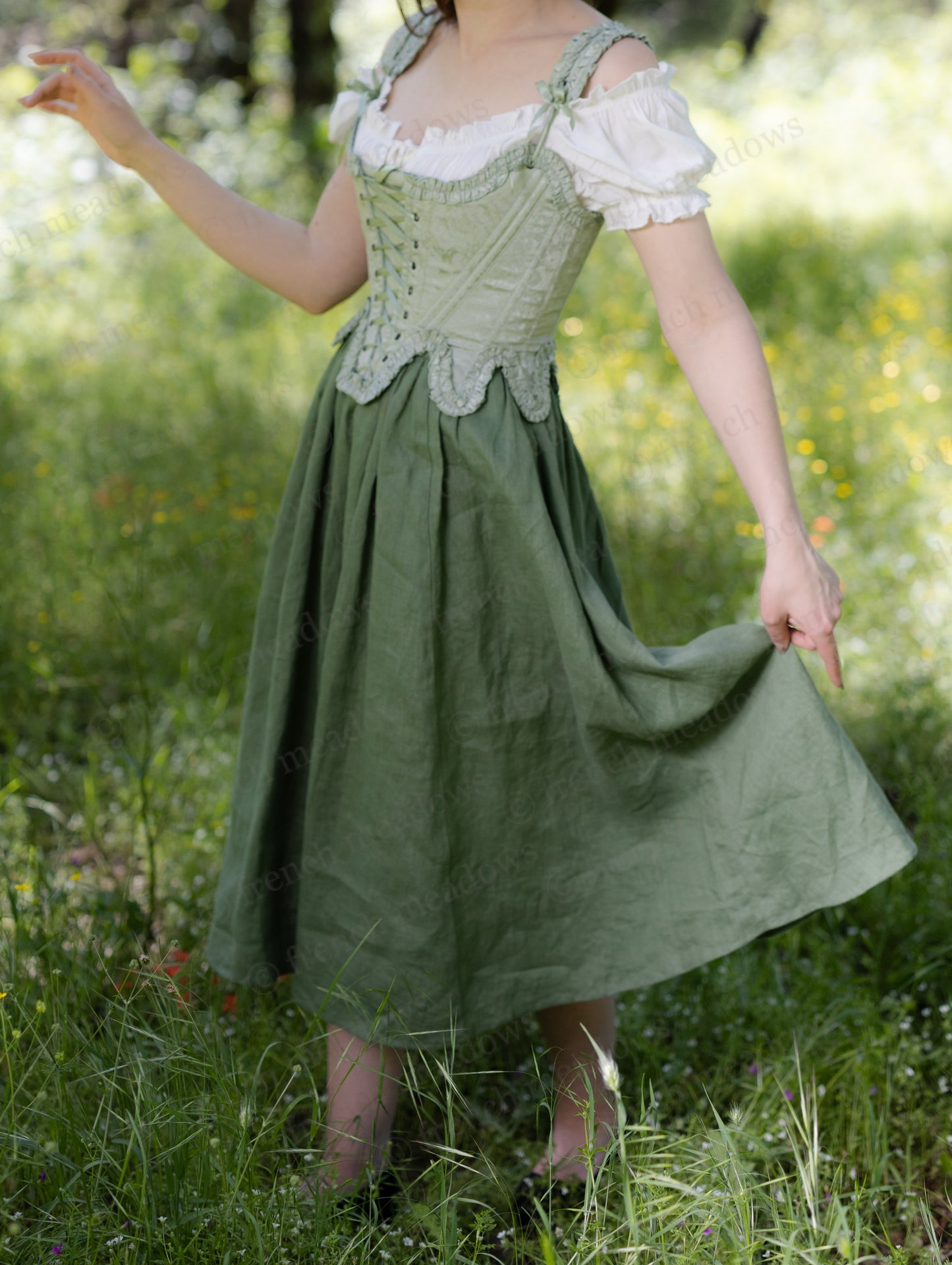 Woman wearing an Ivy Green Linen Midi Skirt with a corset and blouse in a sunlit meadow.
