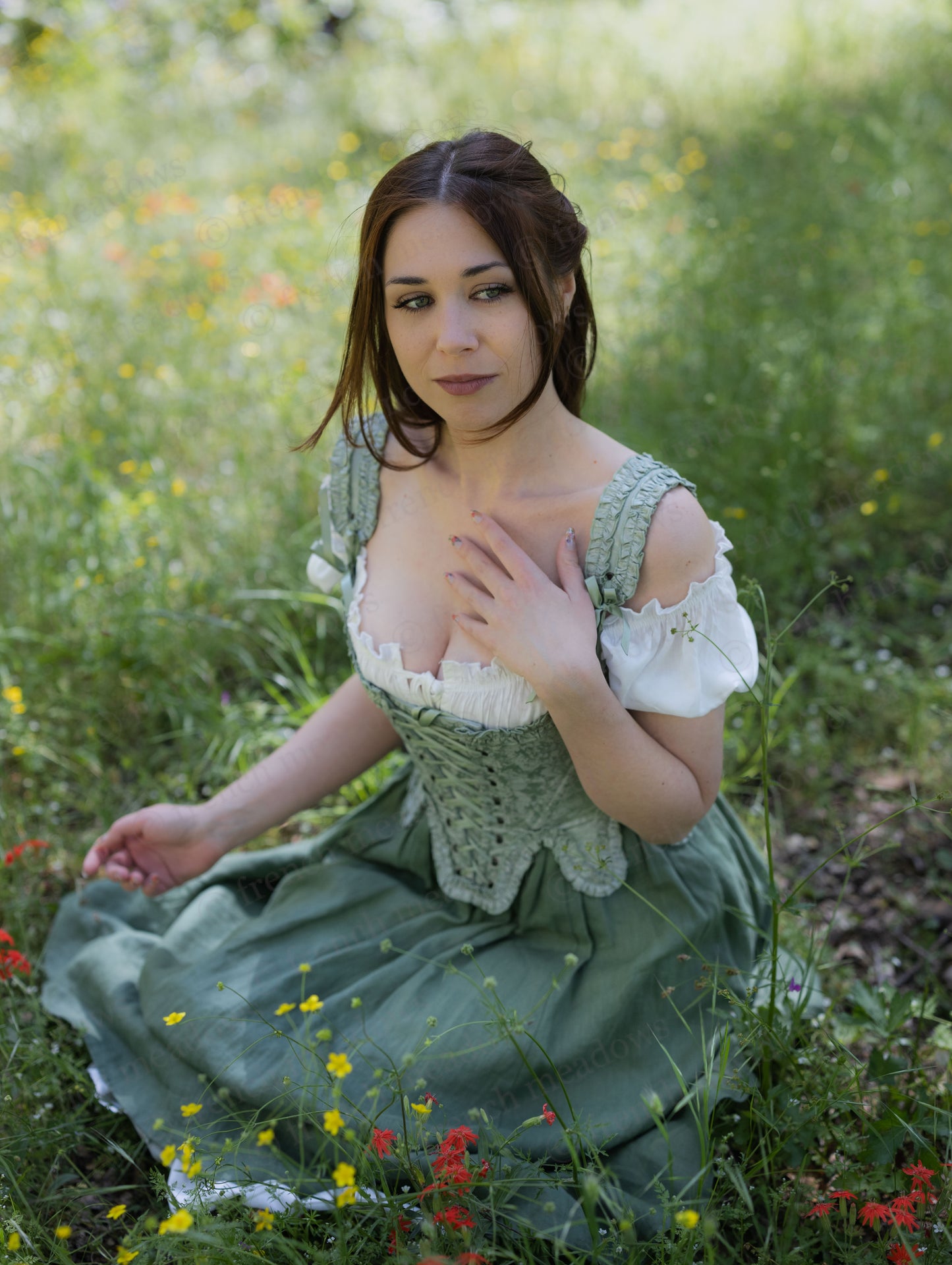 Mint Green Floral 18th Century Stays worn by a woman seated in a grassy field with ruffled neckline and waist details.