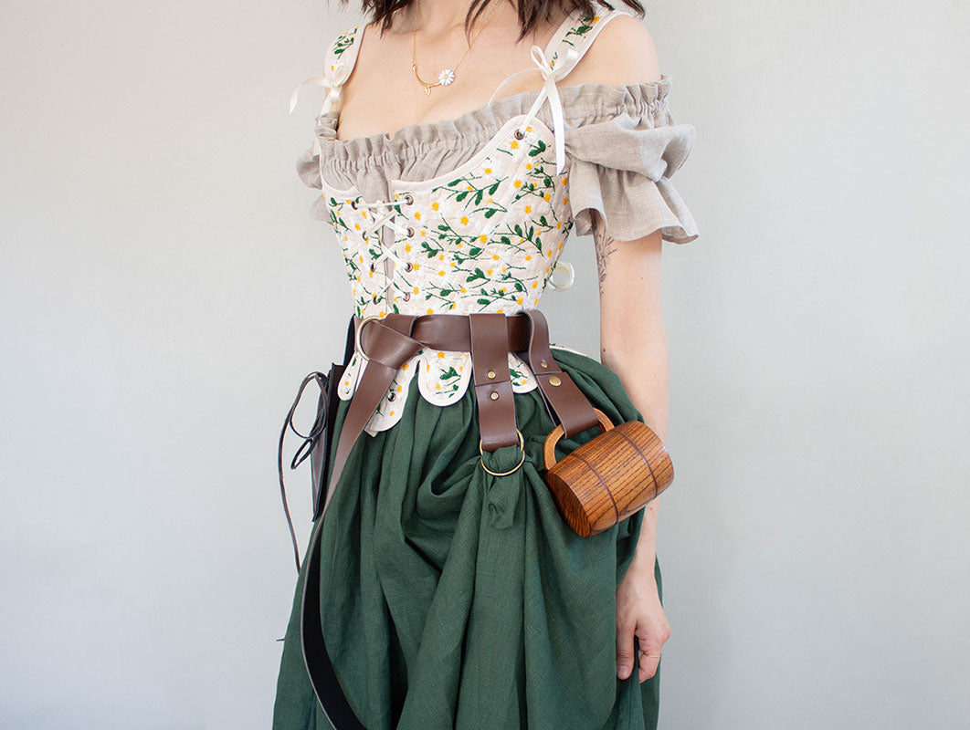 Vegan leather tankard strap shown on renaissance costume with floral dress and green skirt, holding wooden mug