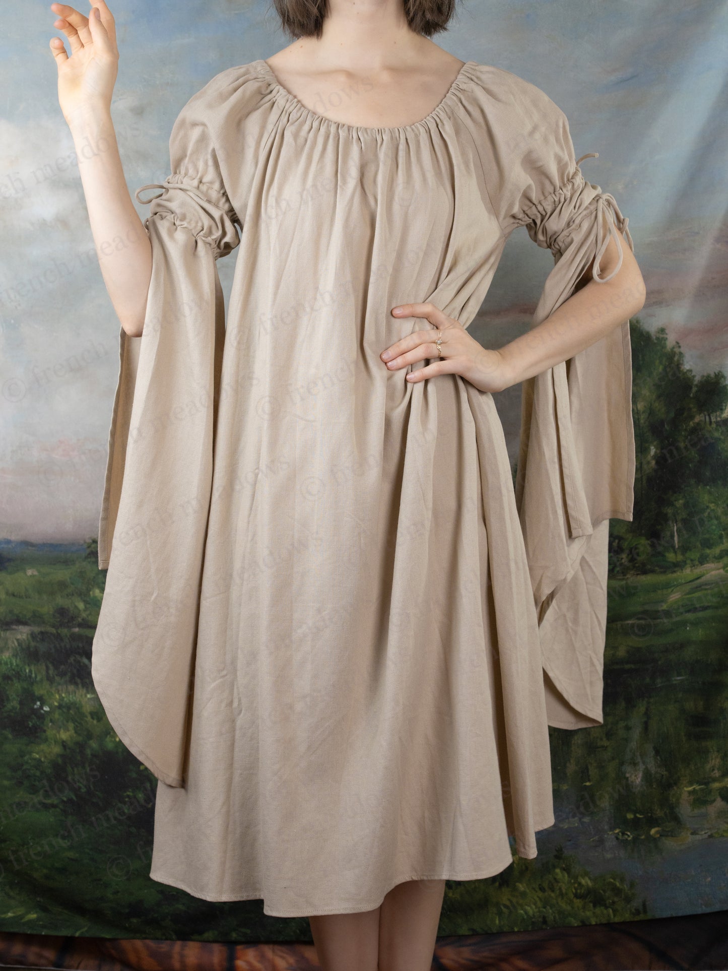 Natural Linen Bell Sleeve Chemise with flowing medieval-style dress shown on countryside backdrop, featuring dramatic draped sleeves