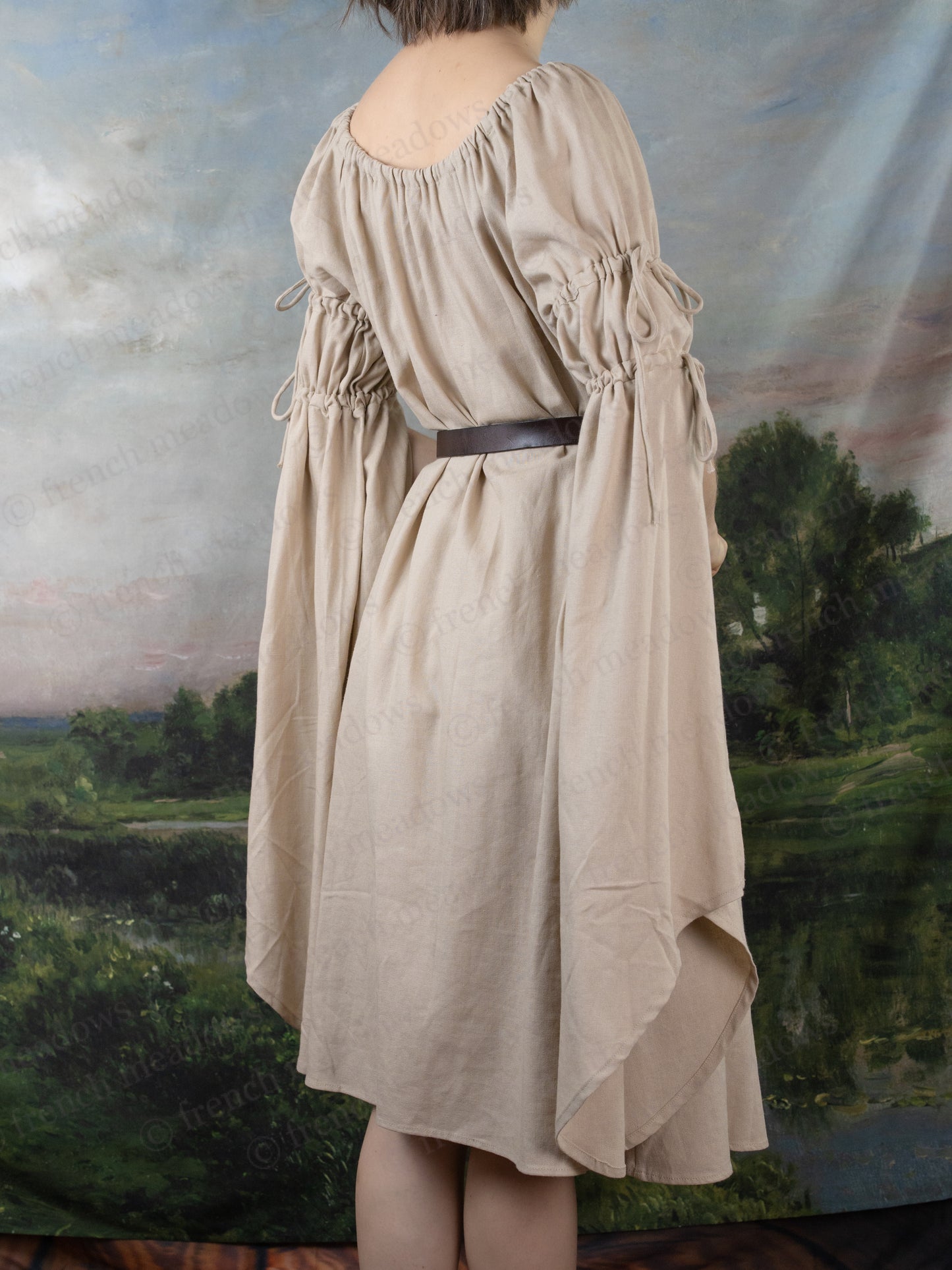 Natural Linen Bell Sleeve Chemise shown from back view, featuring flowing medieval-style sleeves and gathered neckline with brown belt