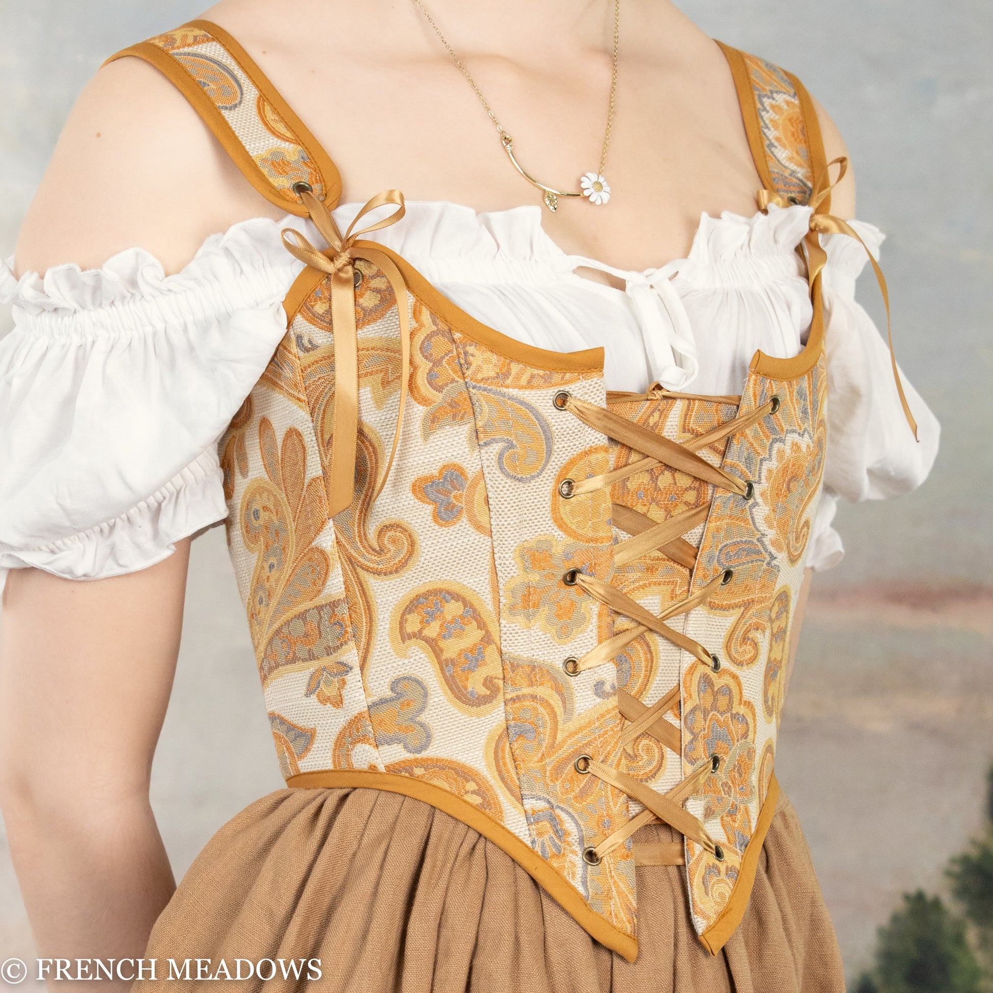 Handmade orange and yellow paisley Renaissance bodice with gold trim and lace-up front on beige jacquard fabric