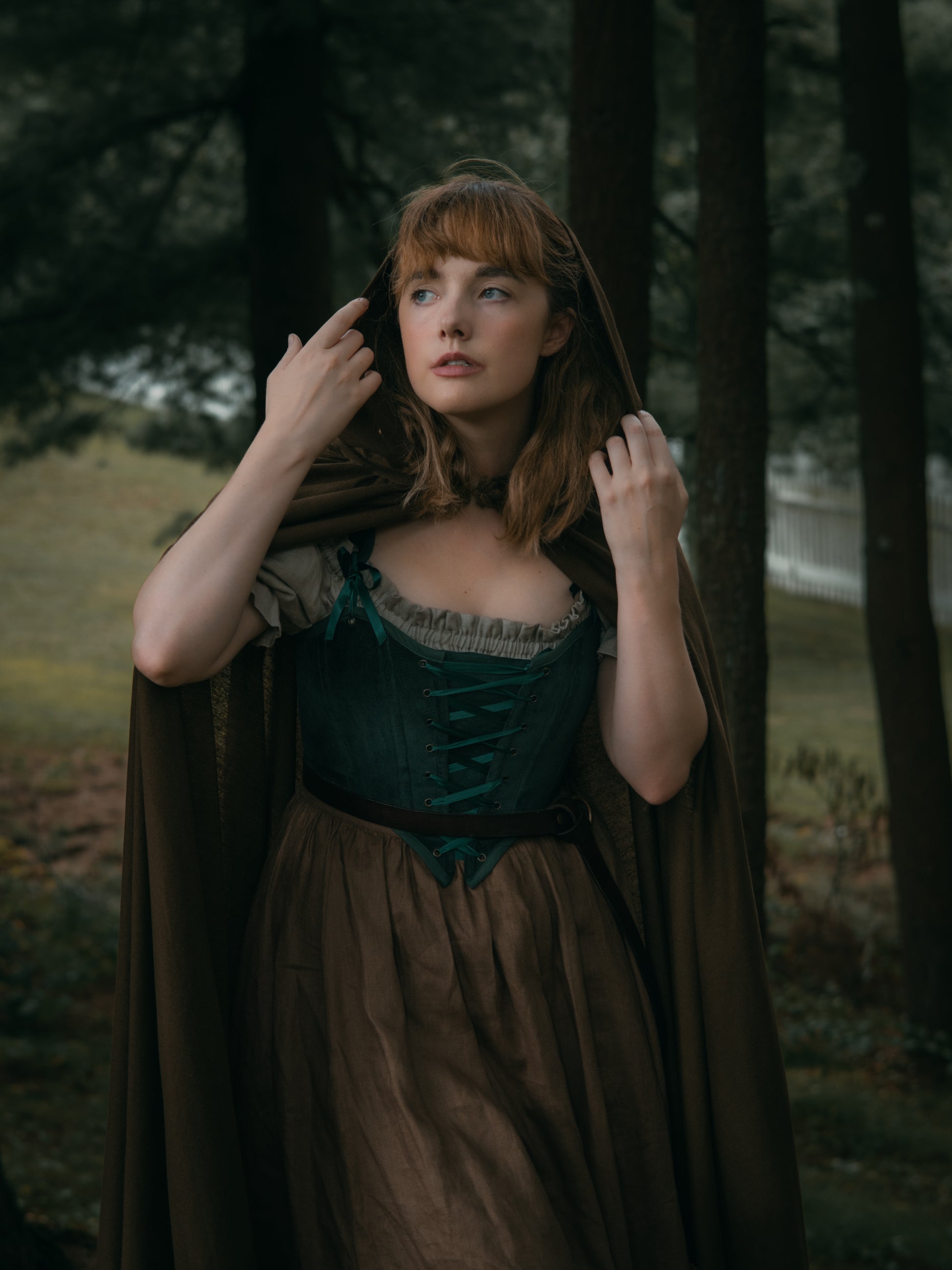 Young woman in forest wearing Linen Renaissance Cloak, styled for renaissance faire or autumn excursions.