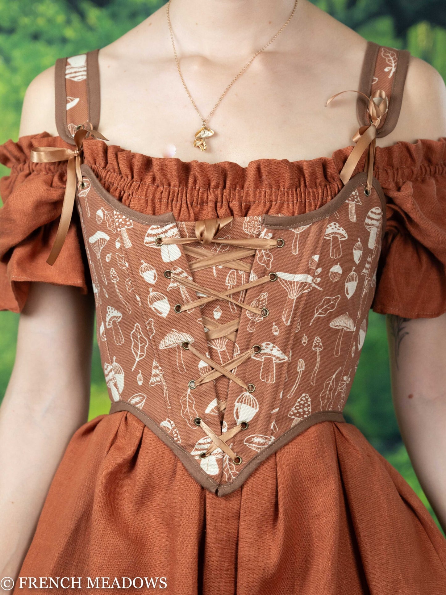 Orange Renaissance bodice with mushroom and acorn print pattern, featuring lace-up front and brown leather straps