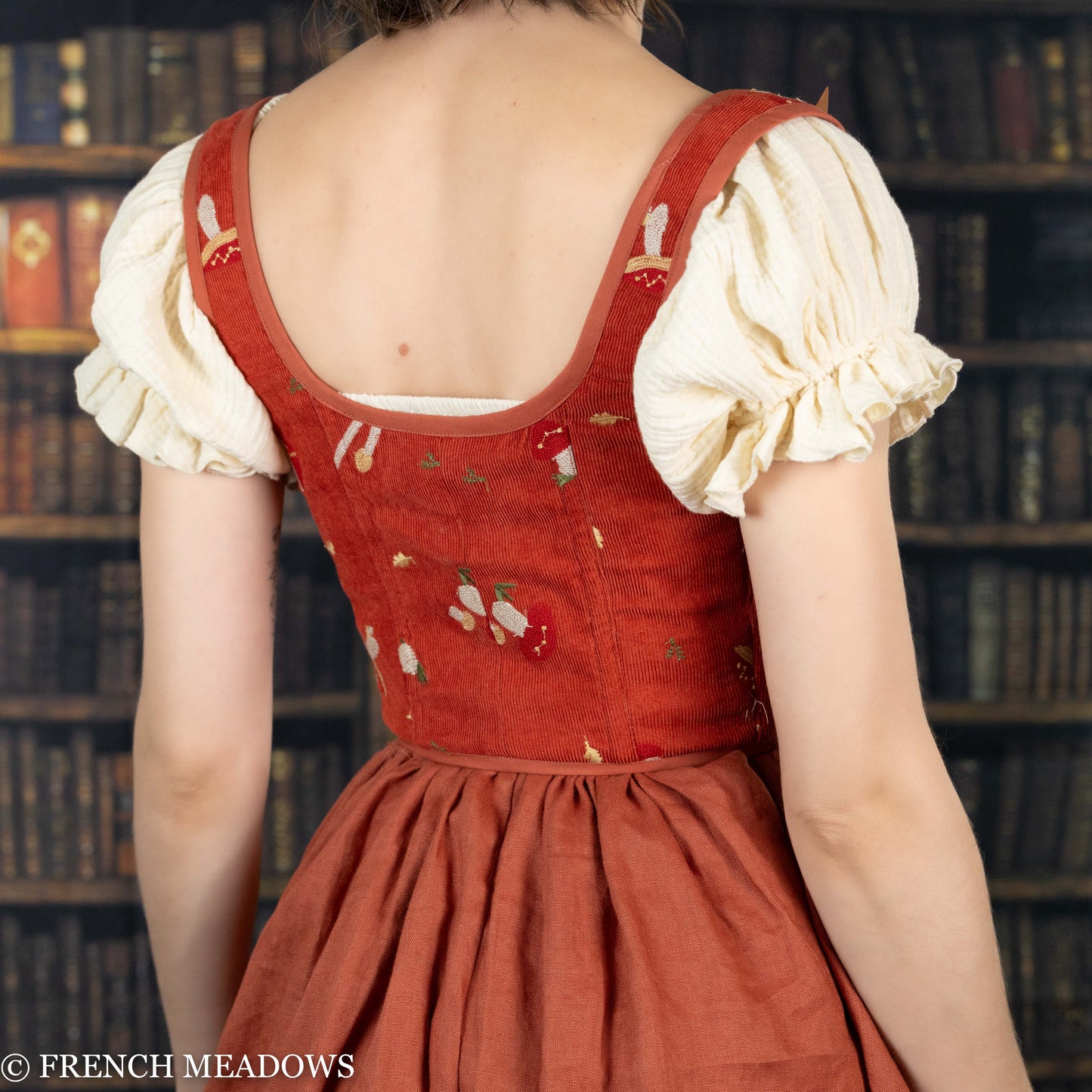 Handmade embroidered mushroom renaissance bodice in burnt orange corduroy with cream puff sleeves, shown from back view