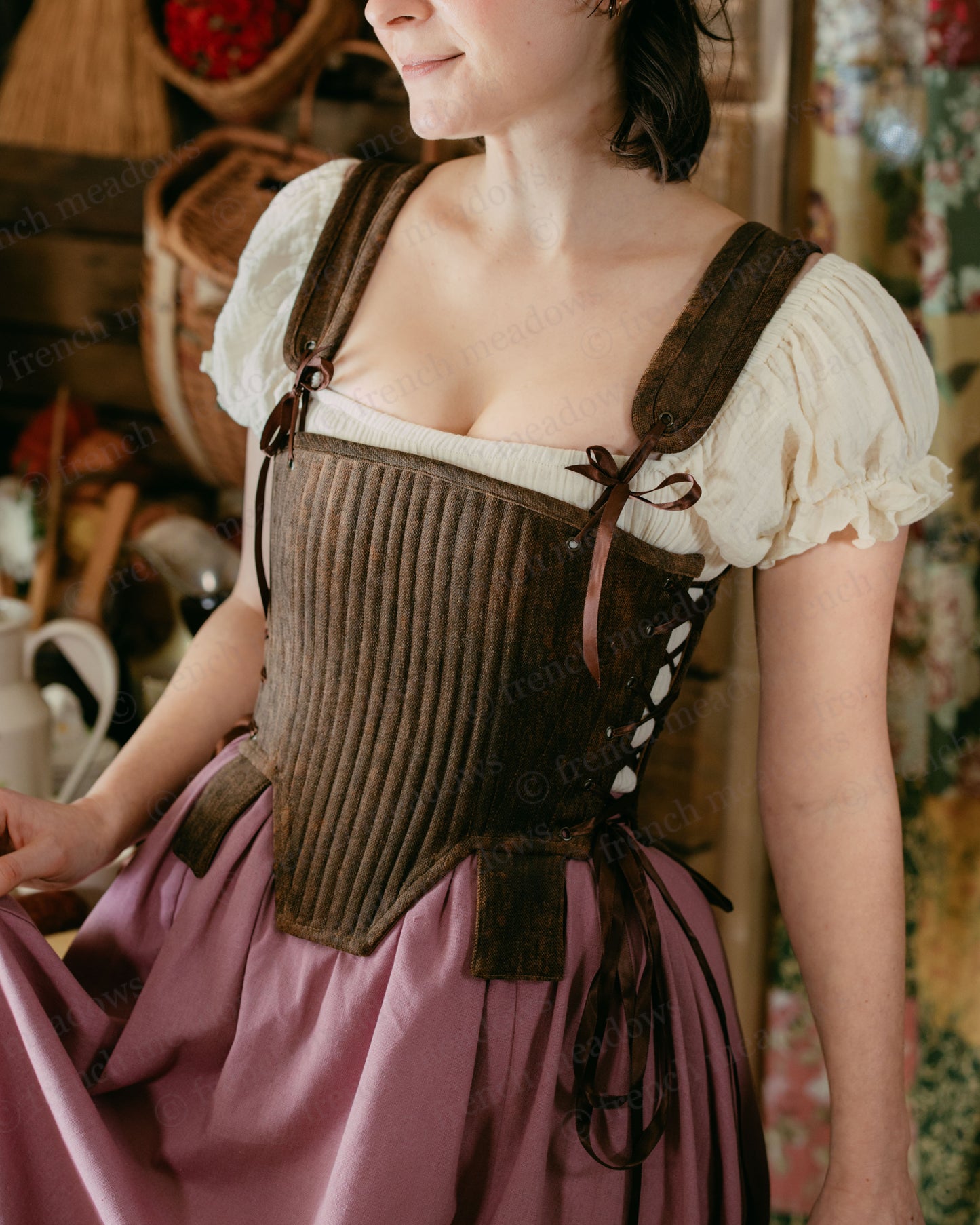 Brown Tabbed Tudor Stays with cream chemise shown over ribbed brown corset with side lacing and decorative tabs, paired with pink skirt
