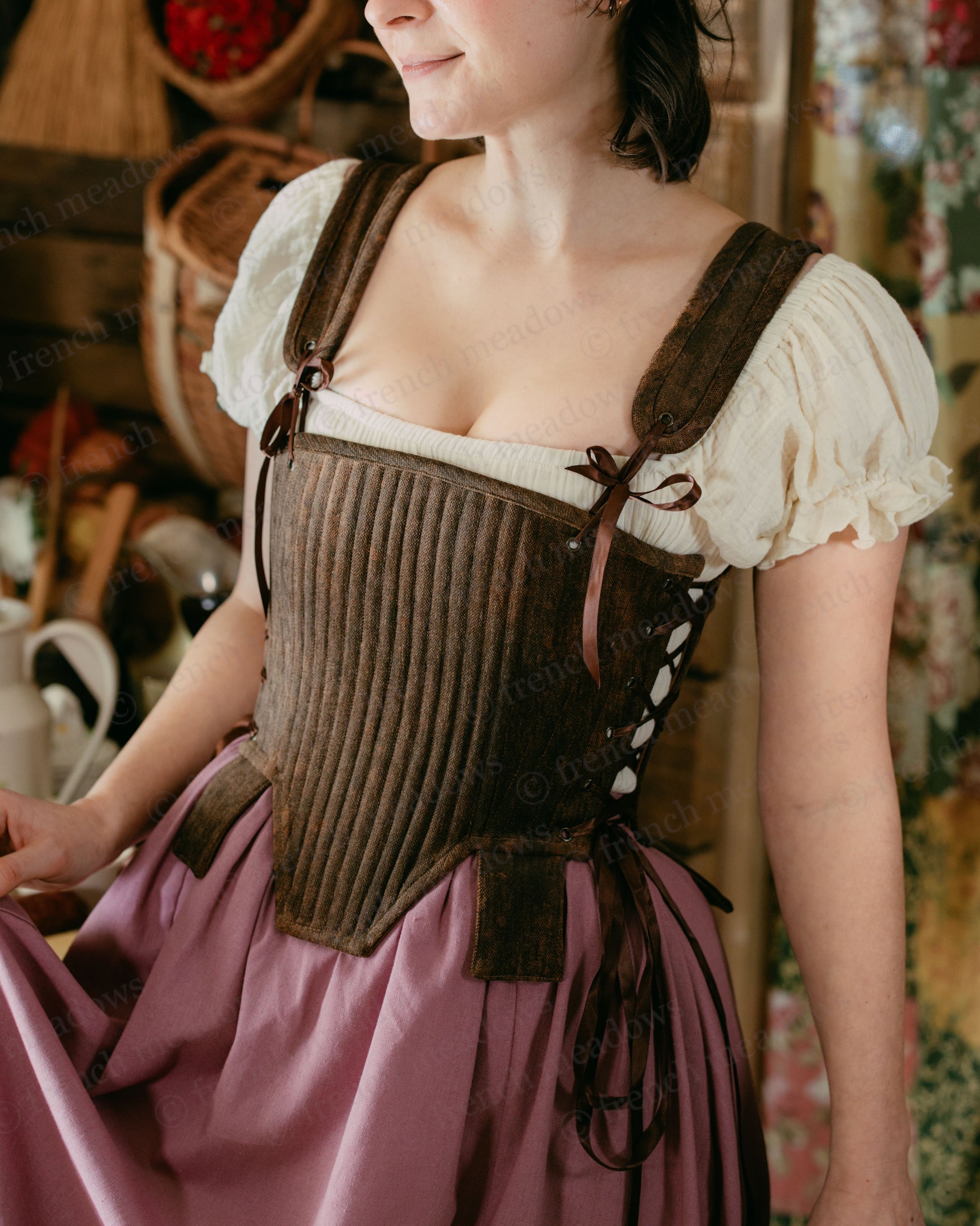Brown Tabbed Tudor Stays with cream chemise shown over ribbed brown corset with side lacing and decorative tabs, paired with pink skirt