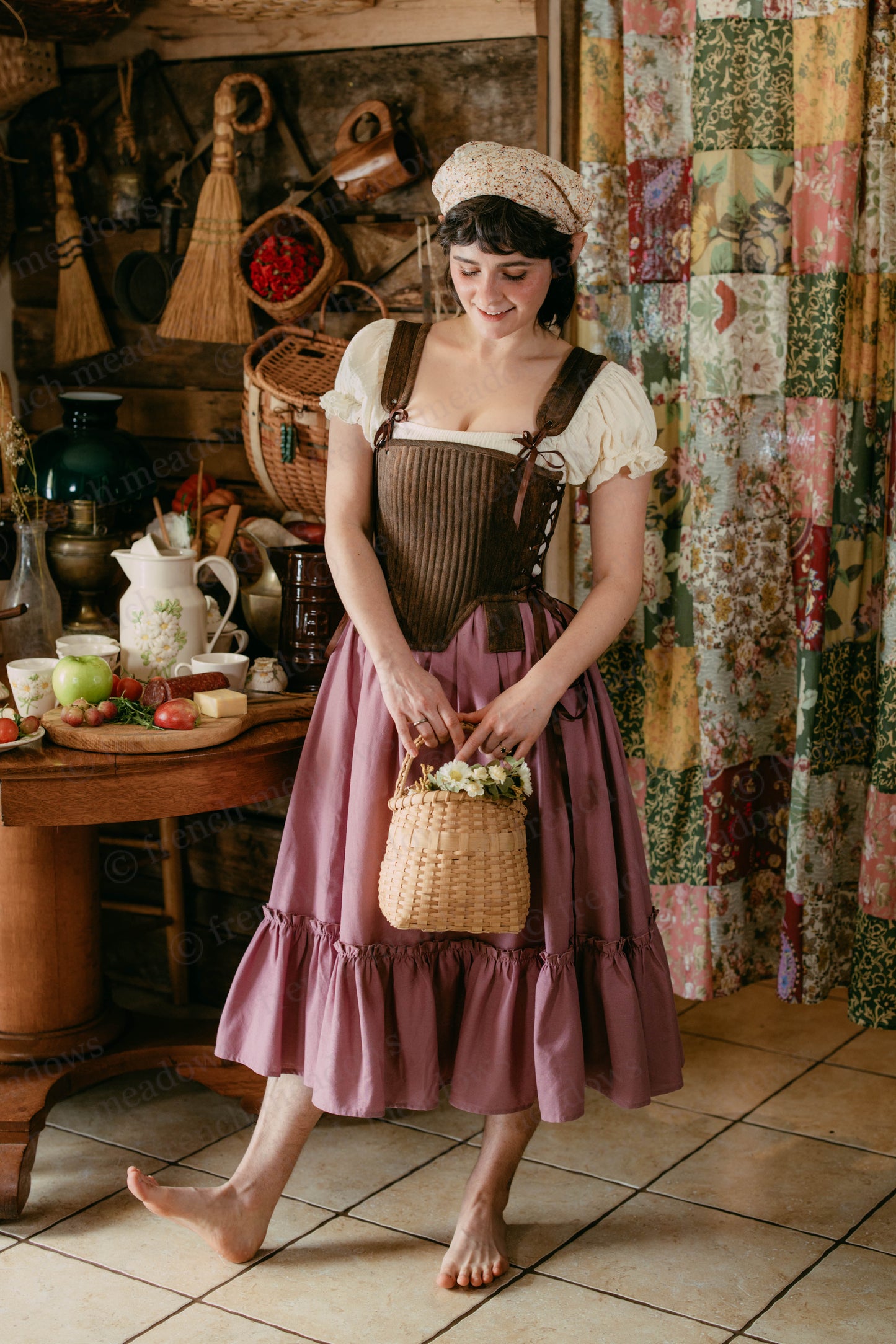 Mauve Linen Ruffle Skirt shown in rustic cottage setting with brown corset top, displaying flowing ruffled hem and cottagecore styling