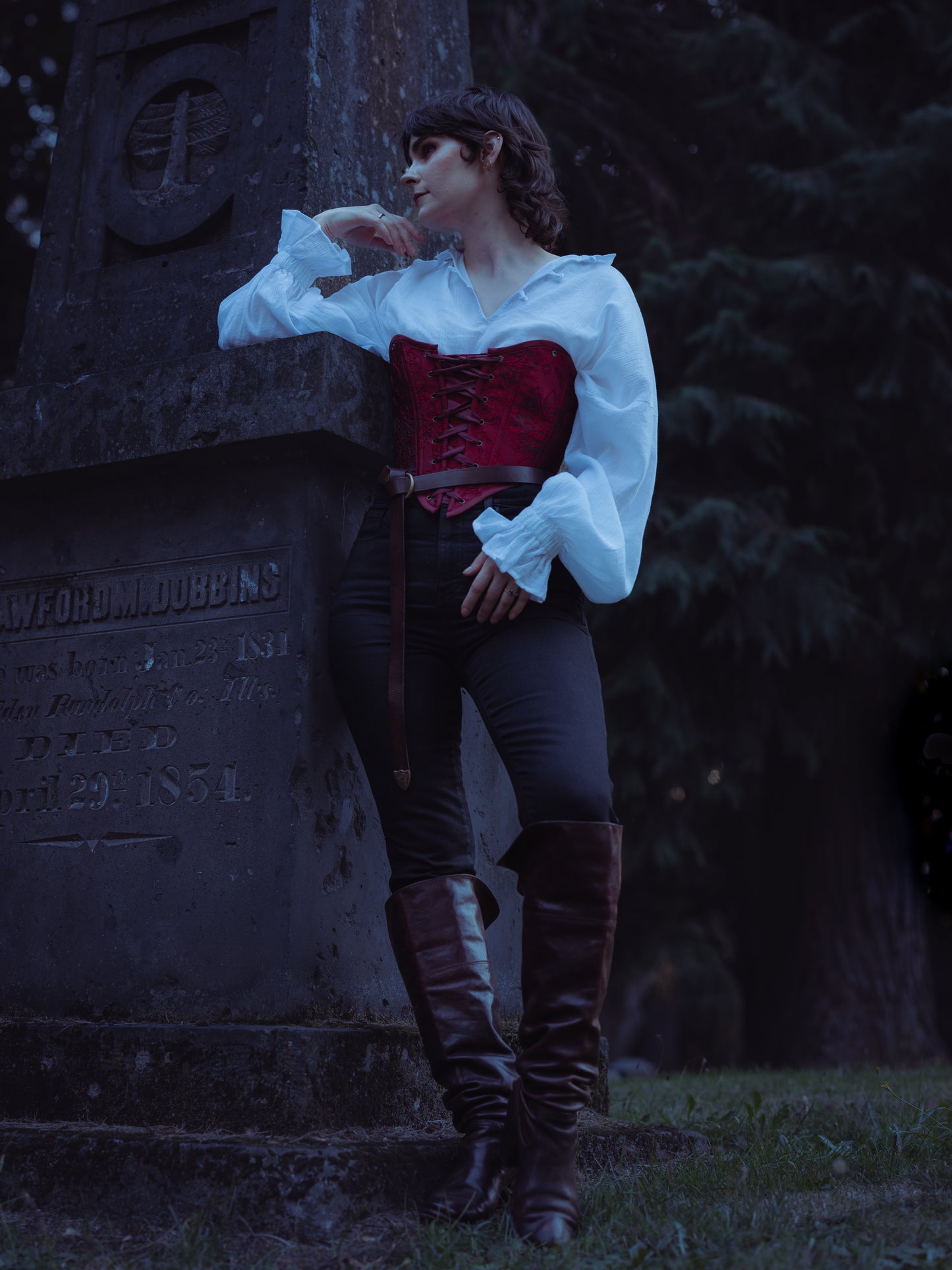 Red Floral Jacquard Corset Top styled with white peasant blouse and boots in gothic cemetery setting at dusk