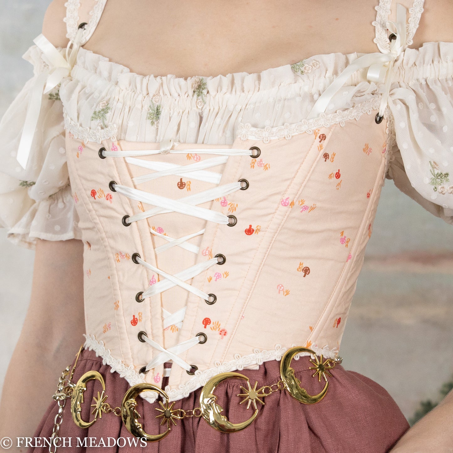 Handmade Ditsy Mushroom Renaissance Bodice with pink fabric, white lace trim, corset lacing, and decorative gold hardware