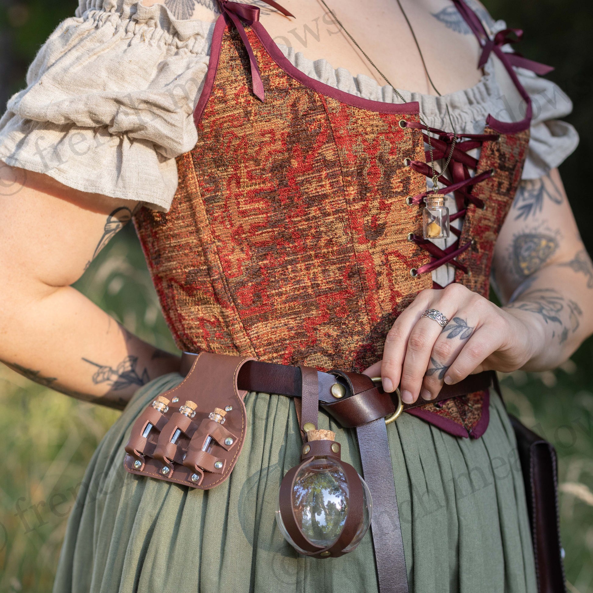 Brown leather potion bottle holder with belt clip attachment shown on Renaissance costume with decorative corset