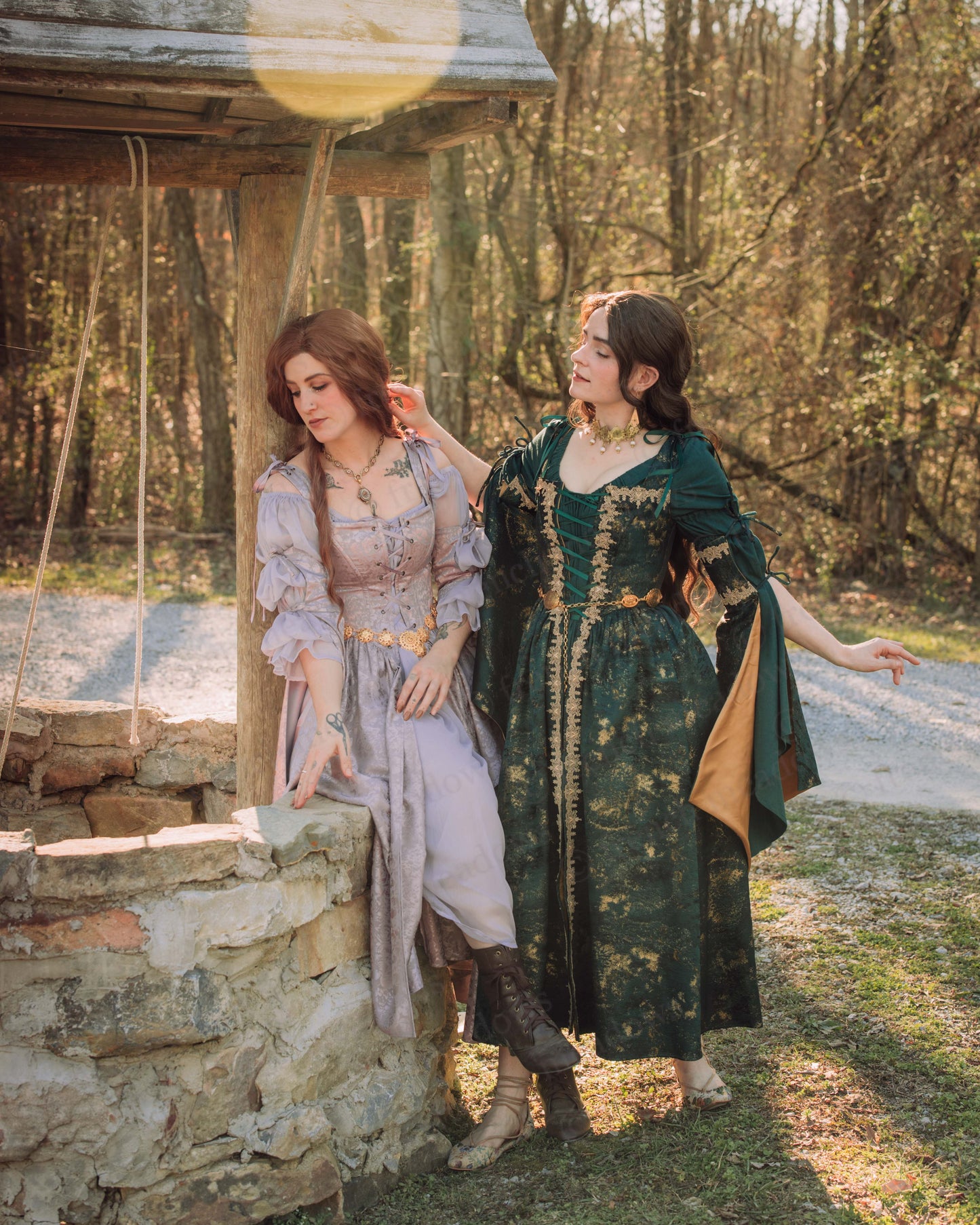 Dark Green Jacquard Corset Dress with gold trim shown outdoors with bell sleeves on model alongside companion in medieval attire