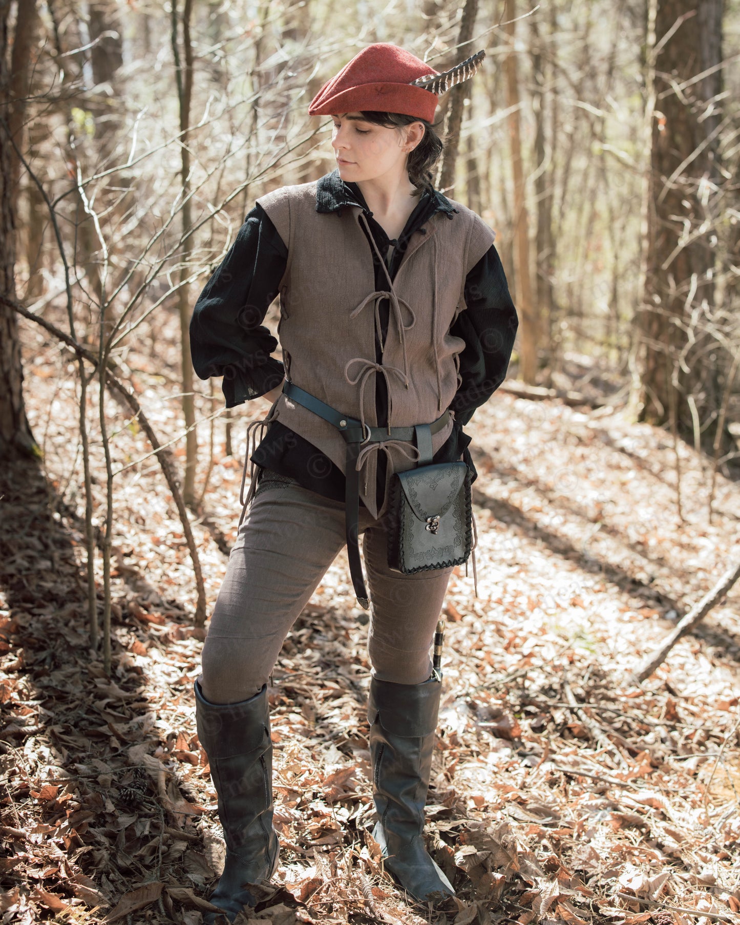Brown Bard Vest shown in woodland setting with side lacing and front ties, styled with feathered cap and leather accessories