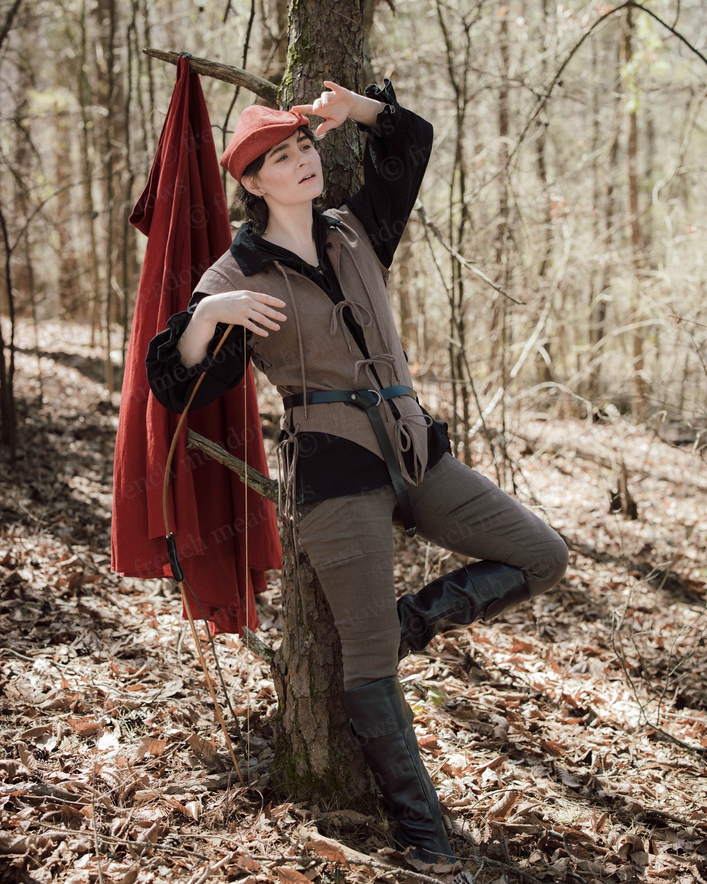Brown Bard Vest shown in woodland setting with red cape, styled with period-appropriate accessories and dramatic forest backdrop
