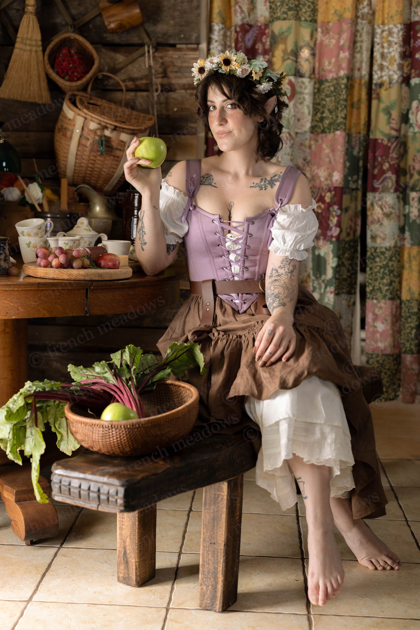 Purple Dusk Satin Corset Top styled in rustic kitchen scene with floral crown, vegetables, and vintage cottage decor