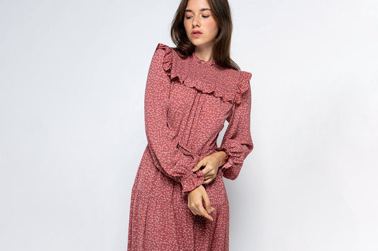 Ruffled Prairie Dress in mauve with floral print, smocked yoke, bishop sleeves and tiered skirt ruffles on model against white background
