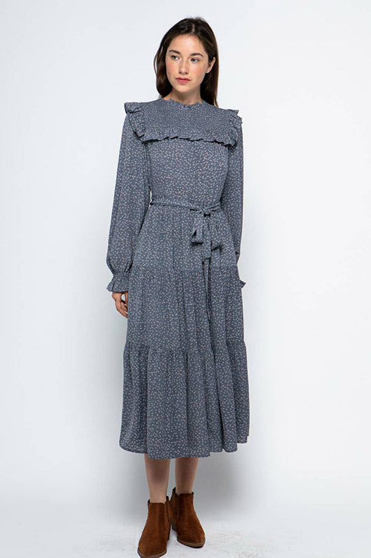 Ruffled Prairie Dress in blue floral print featuring smocked yoke, bishop sleeves, tie waist and tiered midi length skirt