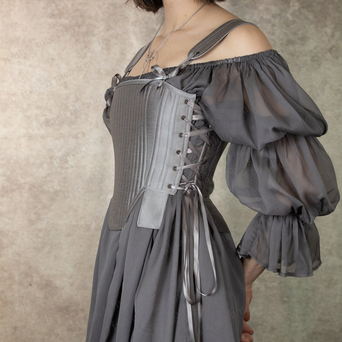 Silver Tabbed Tudor Stays shown from side angle, featuring off-shoulder puff sleeves and front lacing detail in elegant grey fabric