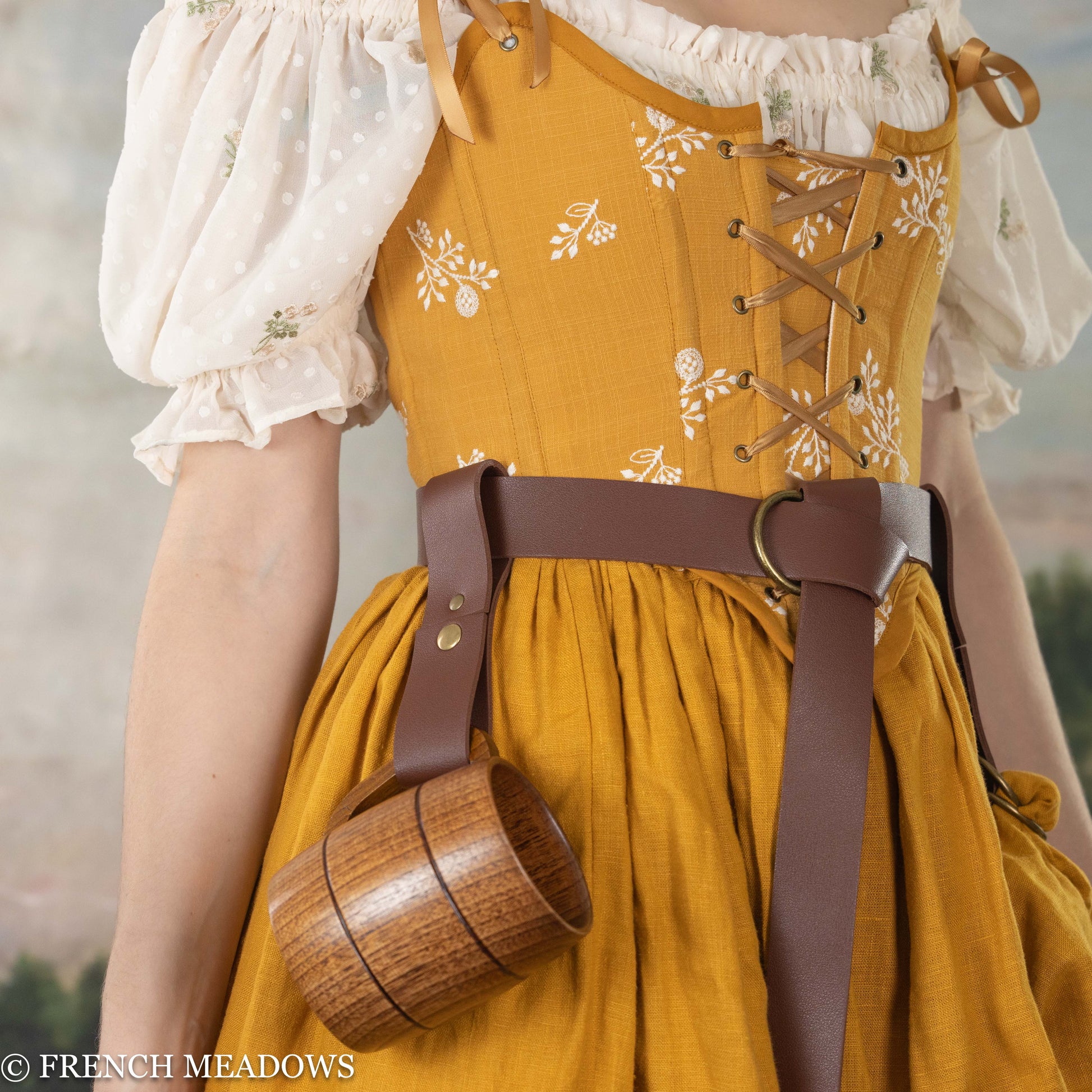 Vegan leather tankard strap shown on brown belt with yellow renaissance dress and wooden mug, perfect for costume wear