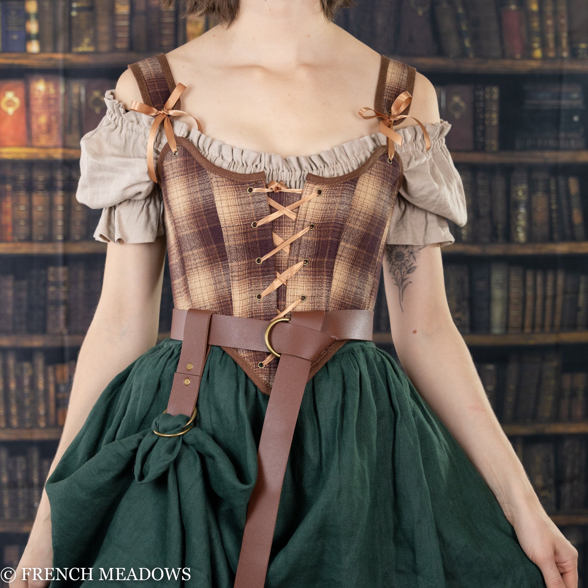 Vegan leather skirt hikes shown on medieval dress with brown leather belt and green renaissance skirt in library setting