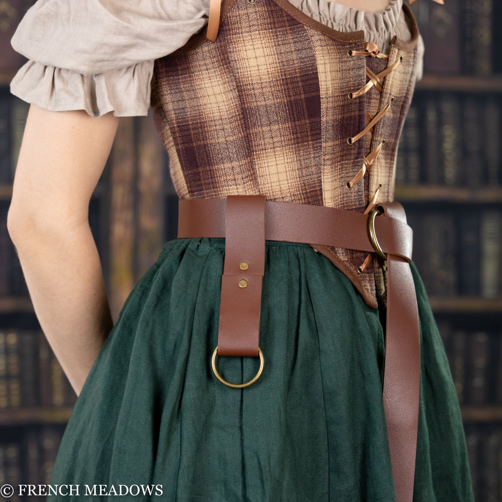 Vegan leather skirt hikes shown with brown leather belt on plaid corset and green renaissance dress