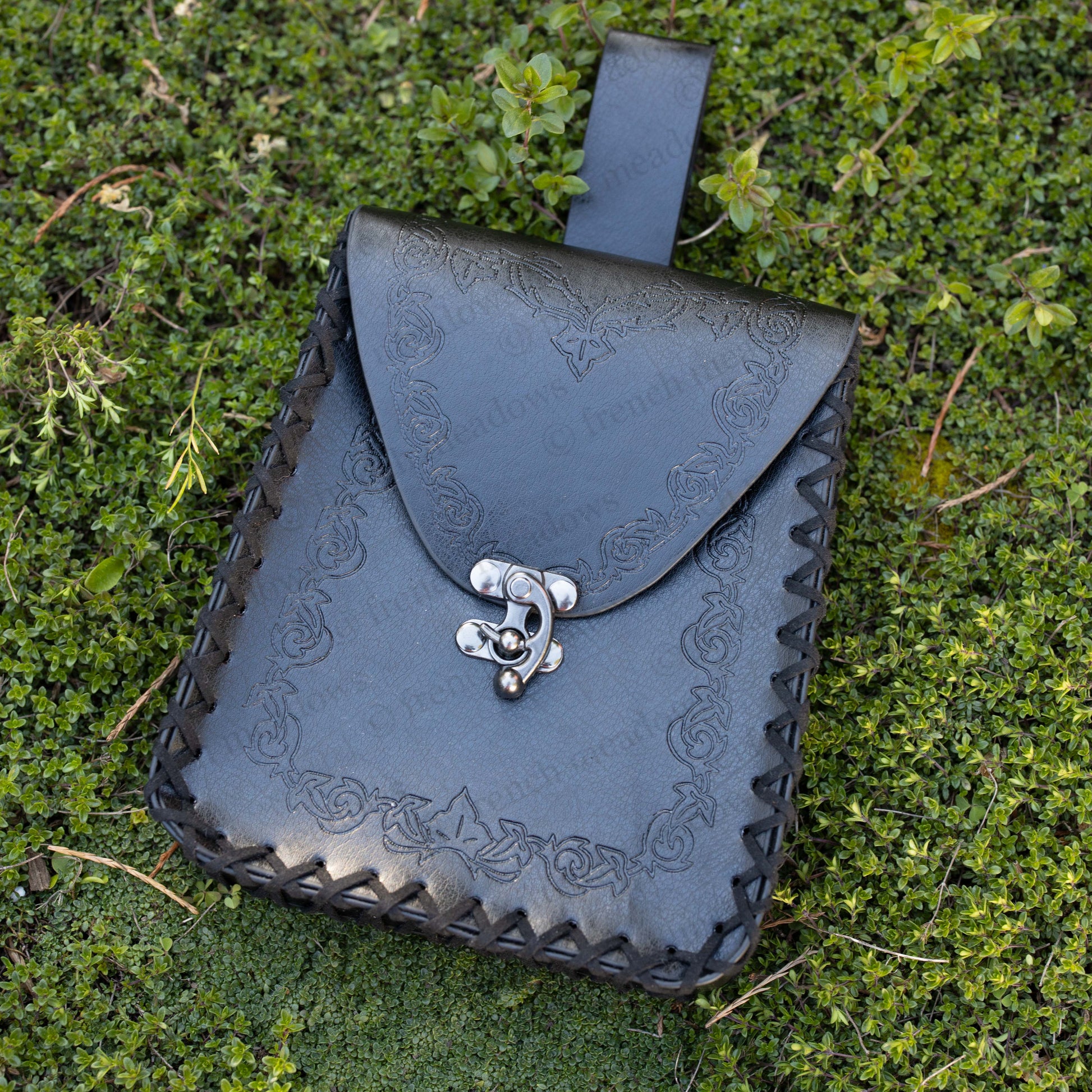 Elven Medieval Belt Pouch with ornate scroll design in black vegan leather on green grass, featuring decorative clasp and belt loop