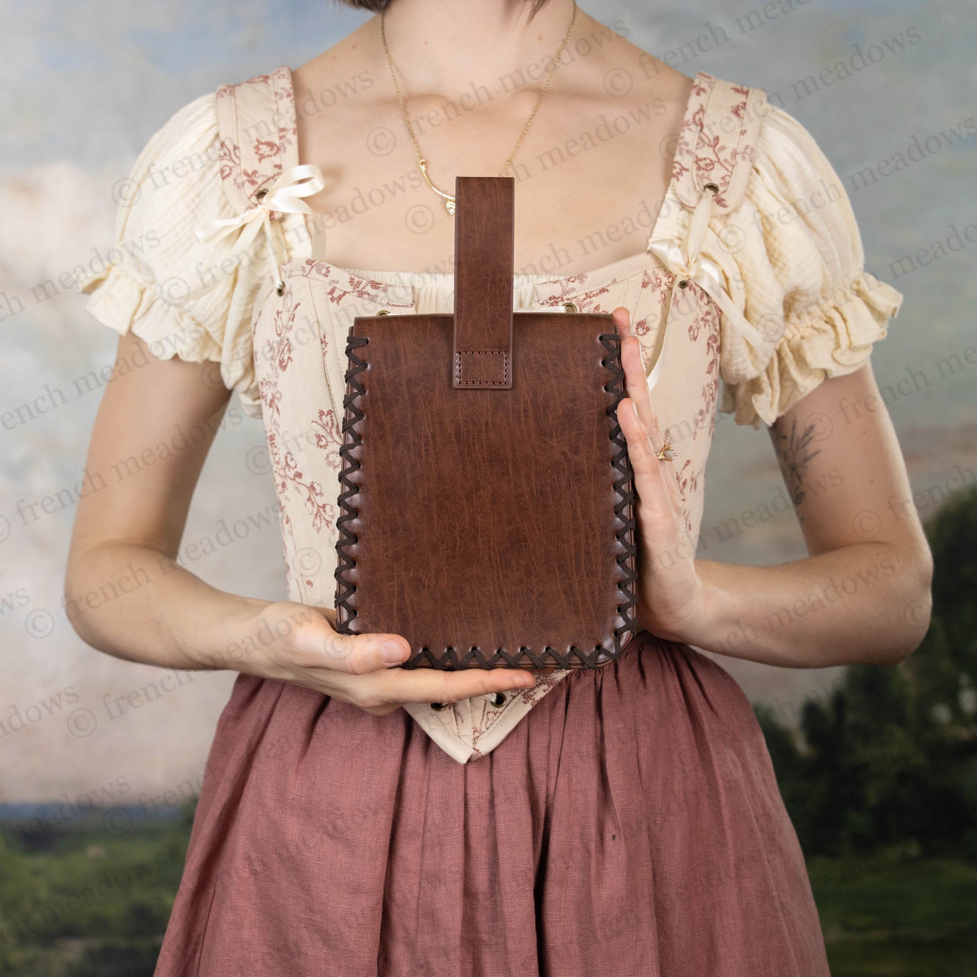 Elven Medieval Belt Pouch in brown vegan leather with decorative stitching shown against medieval dress with lace details