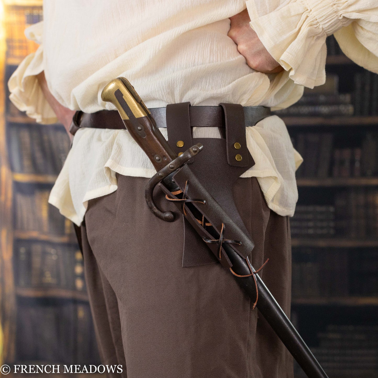 Brown leather sword scabbard with adjustable lacing attached to belt, shown against medieval costume attire