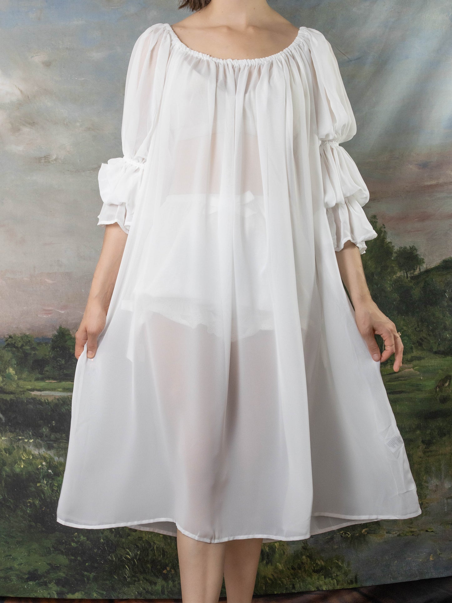 Soft White Chiffon Chemise with off-shoulder design, billowing sleeves and elastic neckline shown against pastoral backdrop