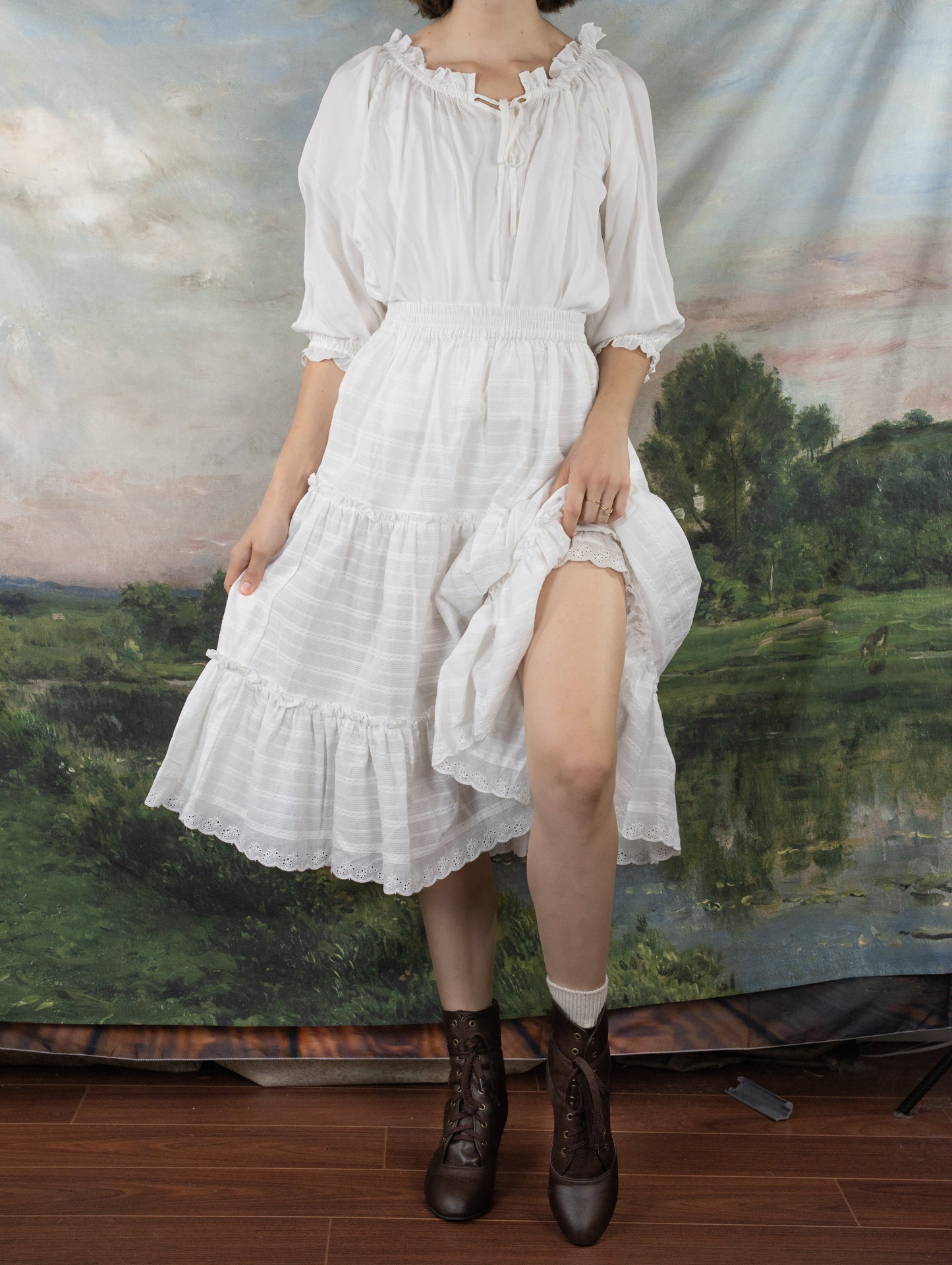 White Cotton Petticoat with tiered ruffles and lace trim shown against pastoral backdrop, features gathered neckline and puff sleeves