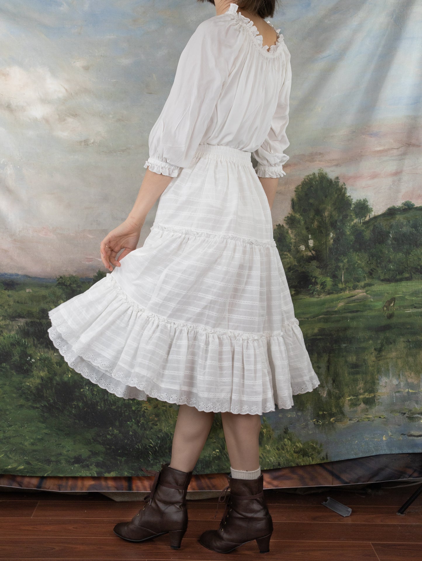 White Cotton Petticoat with tiered ruffles and lace trim shown against pastoral backdrop, worn with brown leather boots