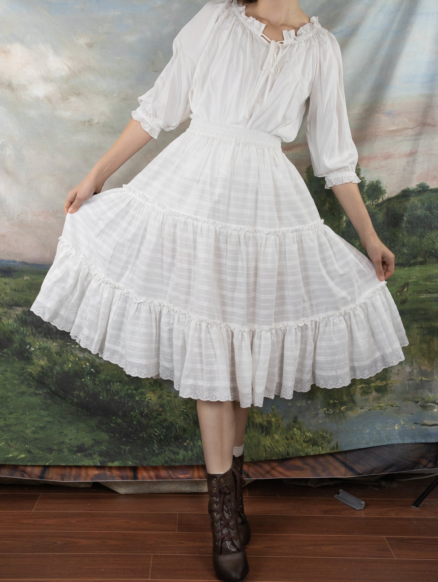 White Cotton Petticoat with tiered ruffles and lace trim shown against pastoral backdrop, modeled with vintage-style boots