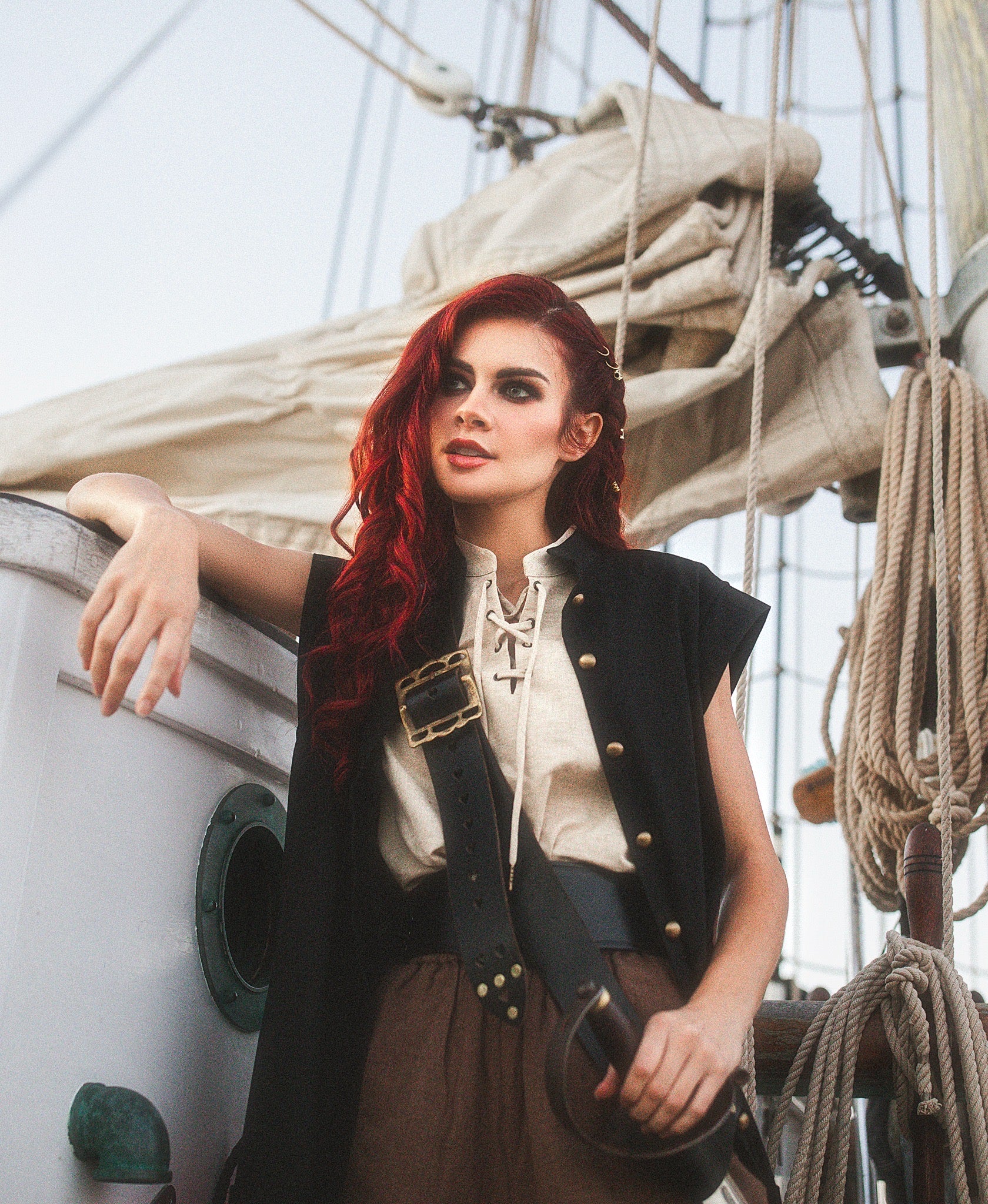 Woman with red hair wearing Linen Sleeveless Pirate Tank with lace-up neckline on a sailboat deck