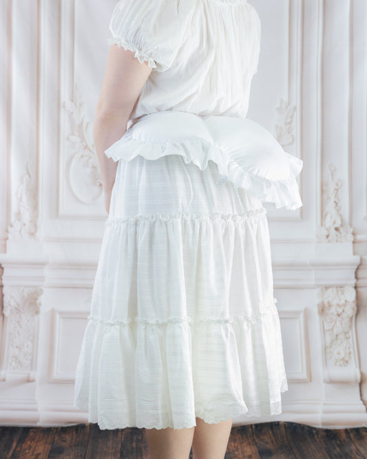 Woman wearing a white skirt with an 18th Century Bustle Pad undergarment adding volume to the back silhouette