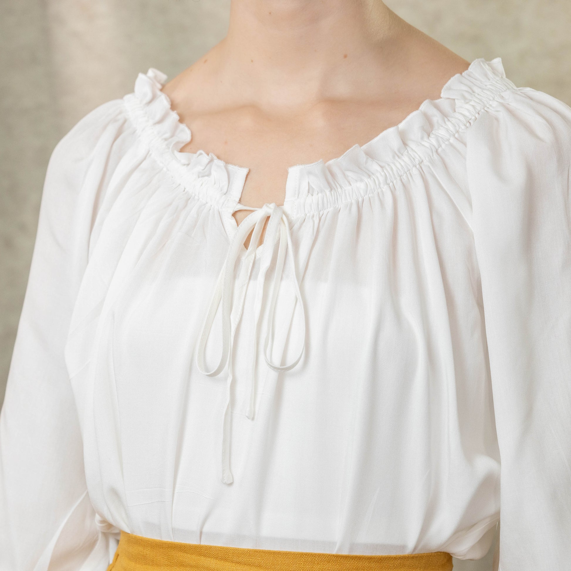 close up view of ruffle neckline on soft white cotton blouse