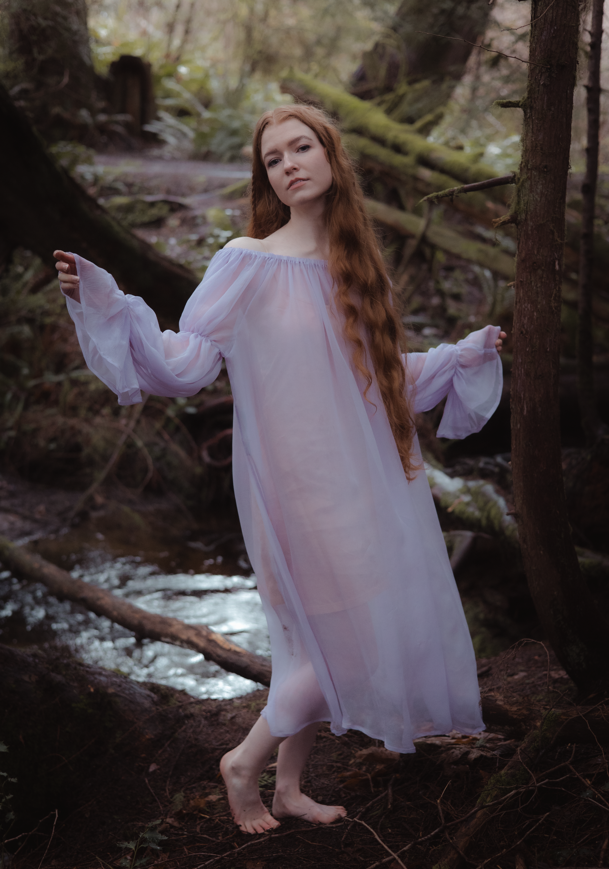 a model wearing a purple fairy dress in the forest