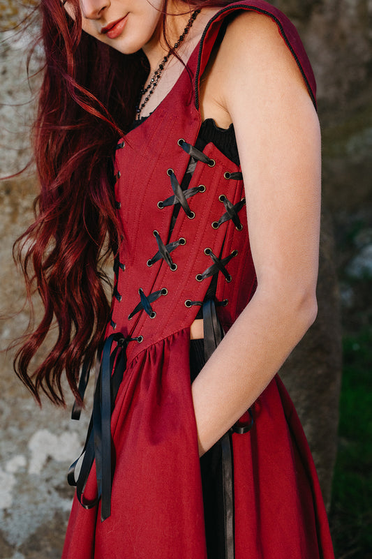 Close-up of woman wearing Red Vampire Slayer Corset Dress with black lacing and boning details in deep red fabric